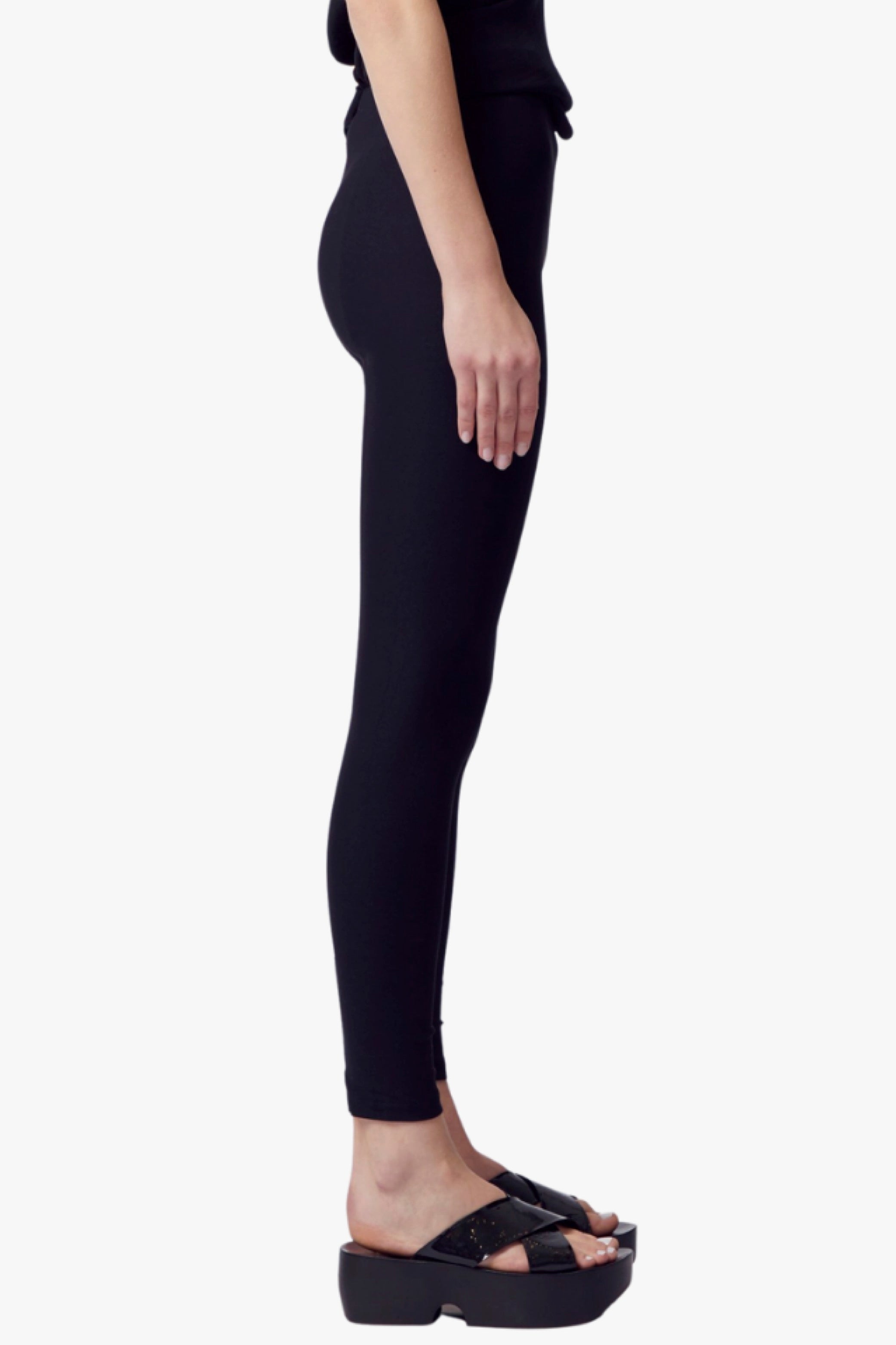 Person wearing black leggings on a white background
