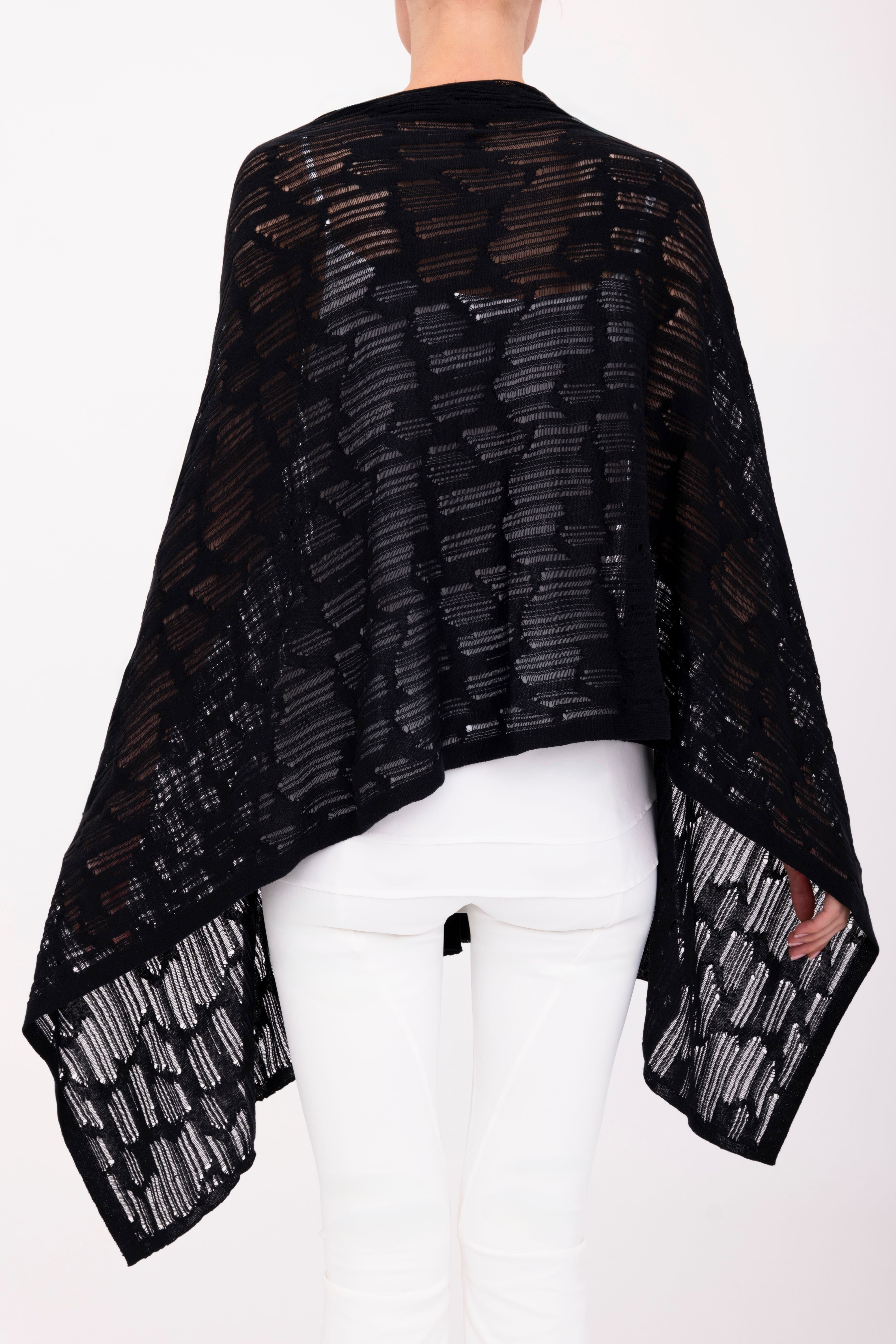 Woman wearing a black poncho top on a white background