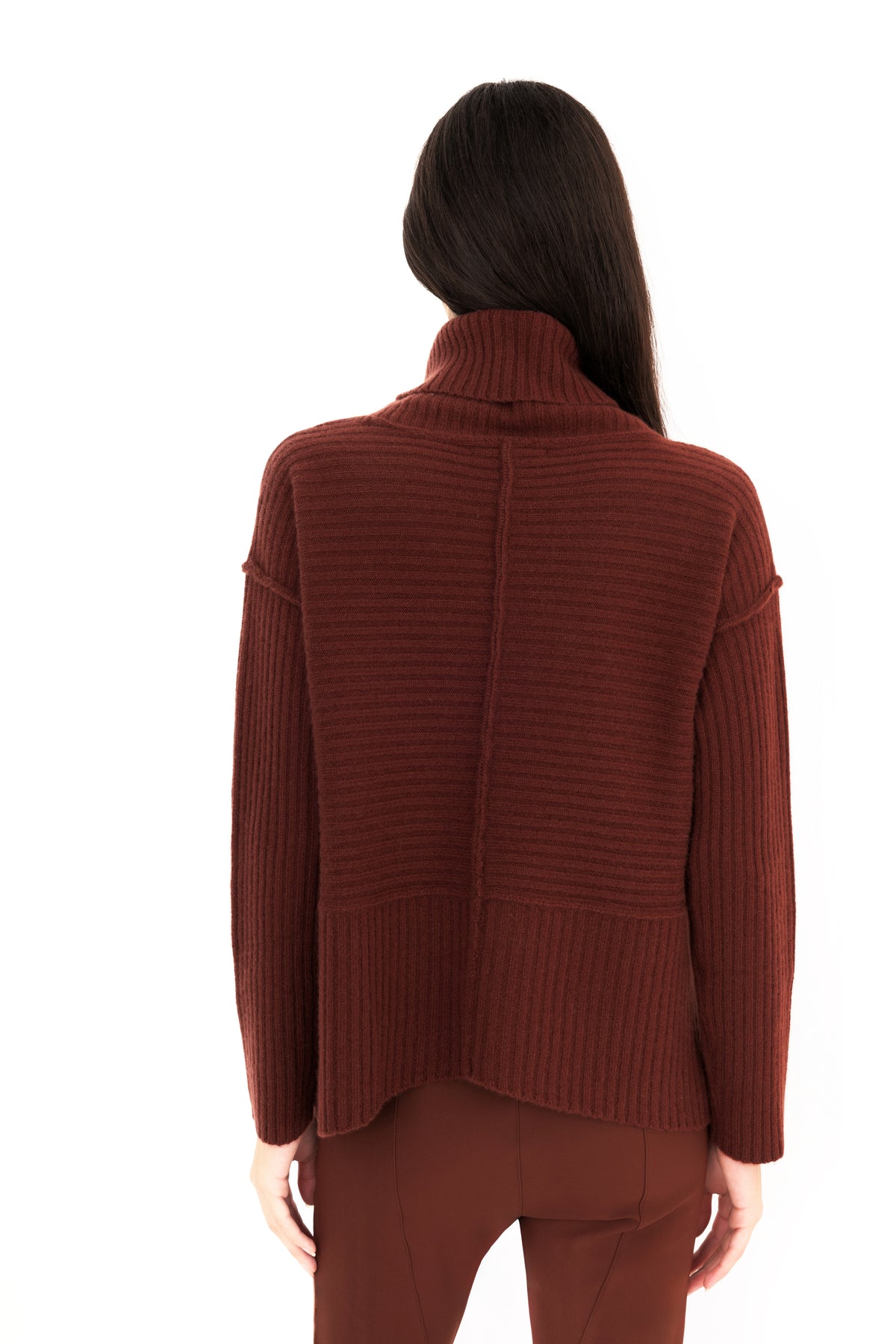 Back view of a woman modeling a ribbed knit funnel-neck sweater in a deep burgundy brown color, paired with matching pants, against a solid white background.