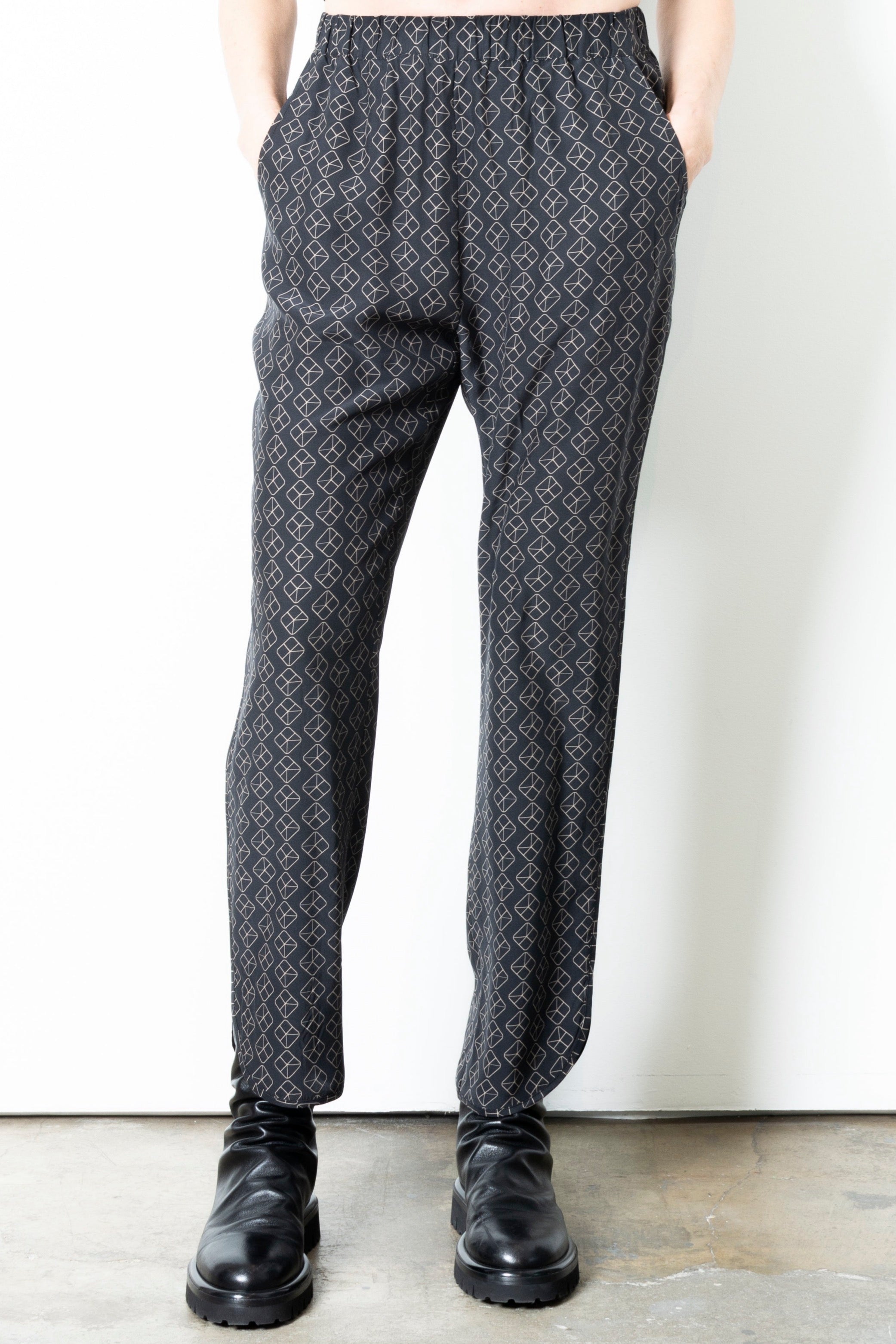 Person wearing patterned pants on a plain background
