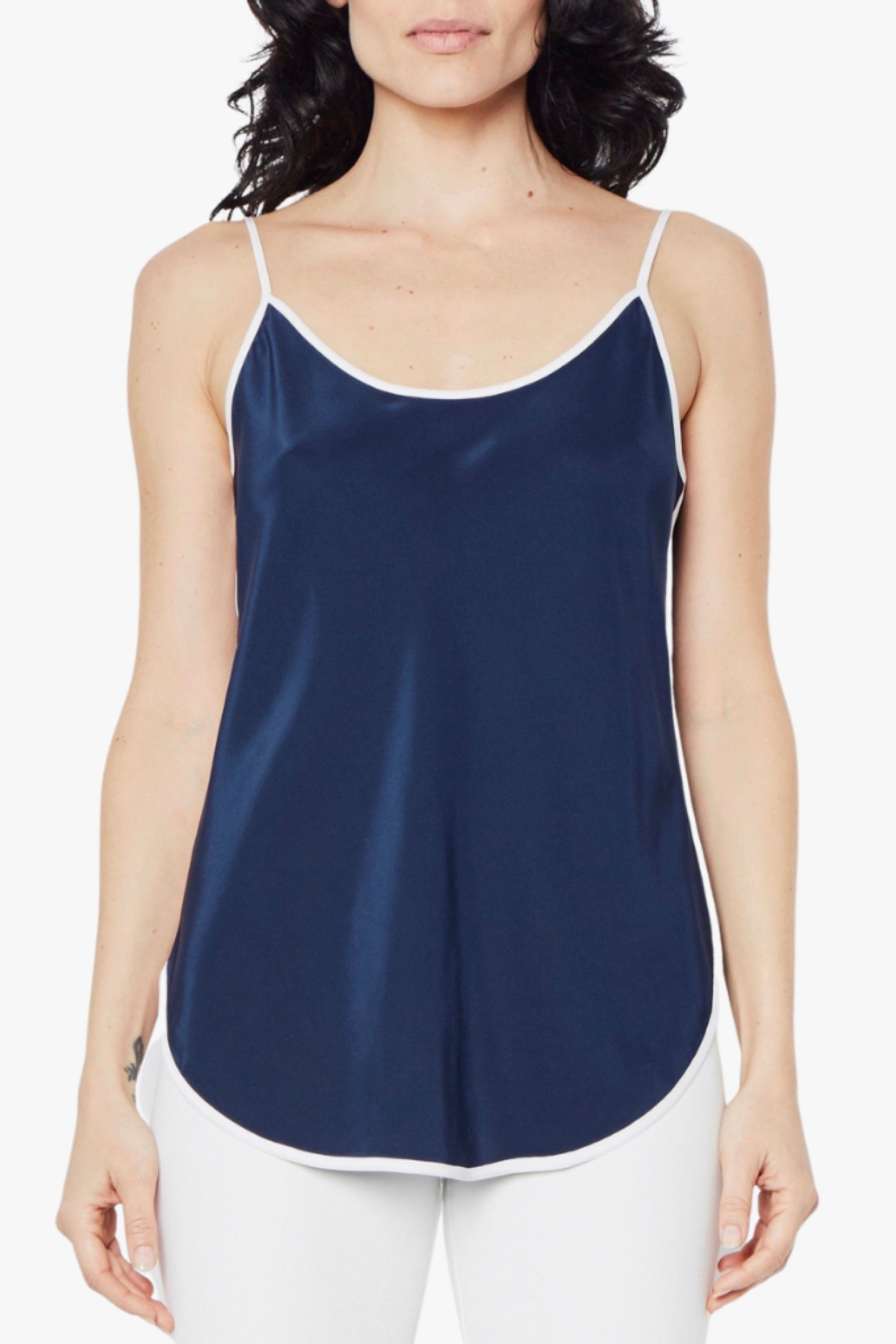 Woman wearing a navy blue camisole against a white background