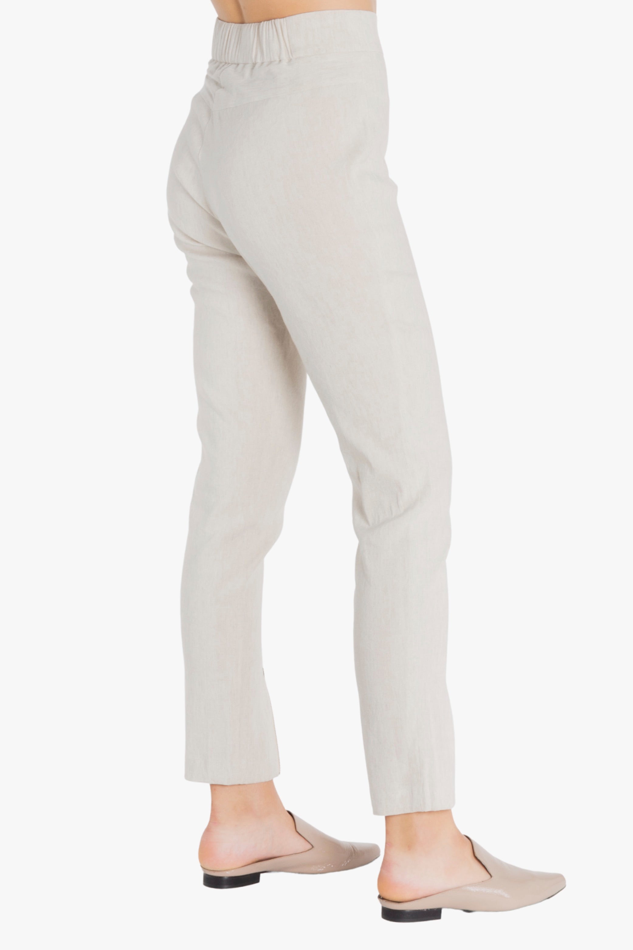 Beige pants worn by a person on a white background