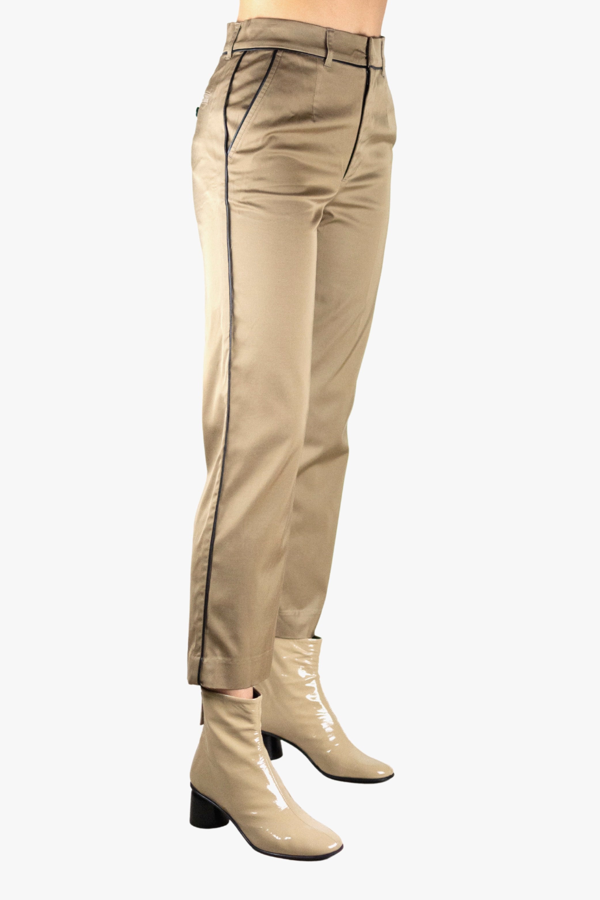 Beige pants with black trim worn by a person on a white background