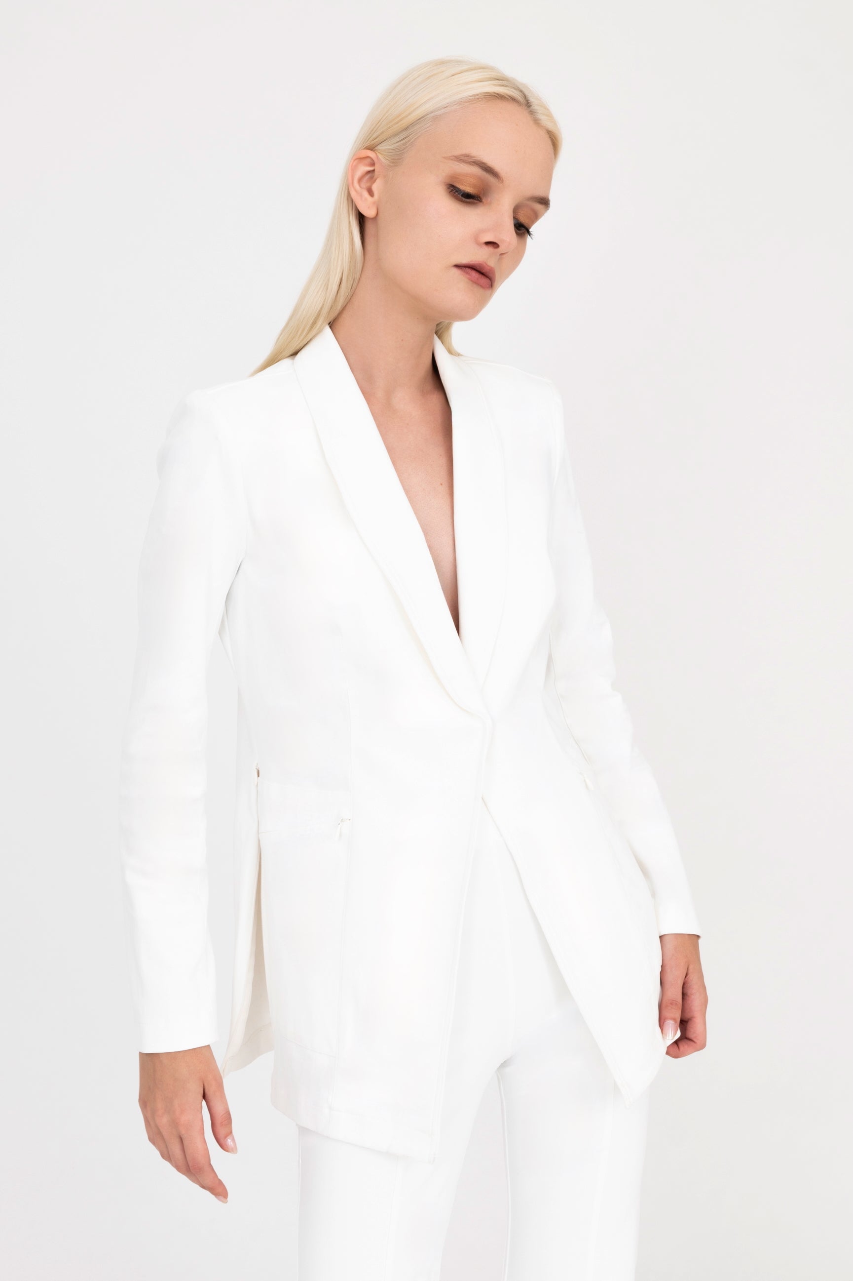 Woman wearing white blazer on a white background