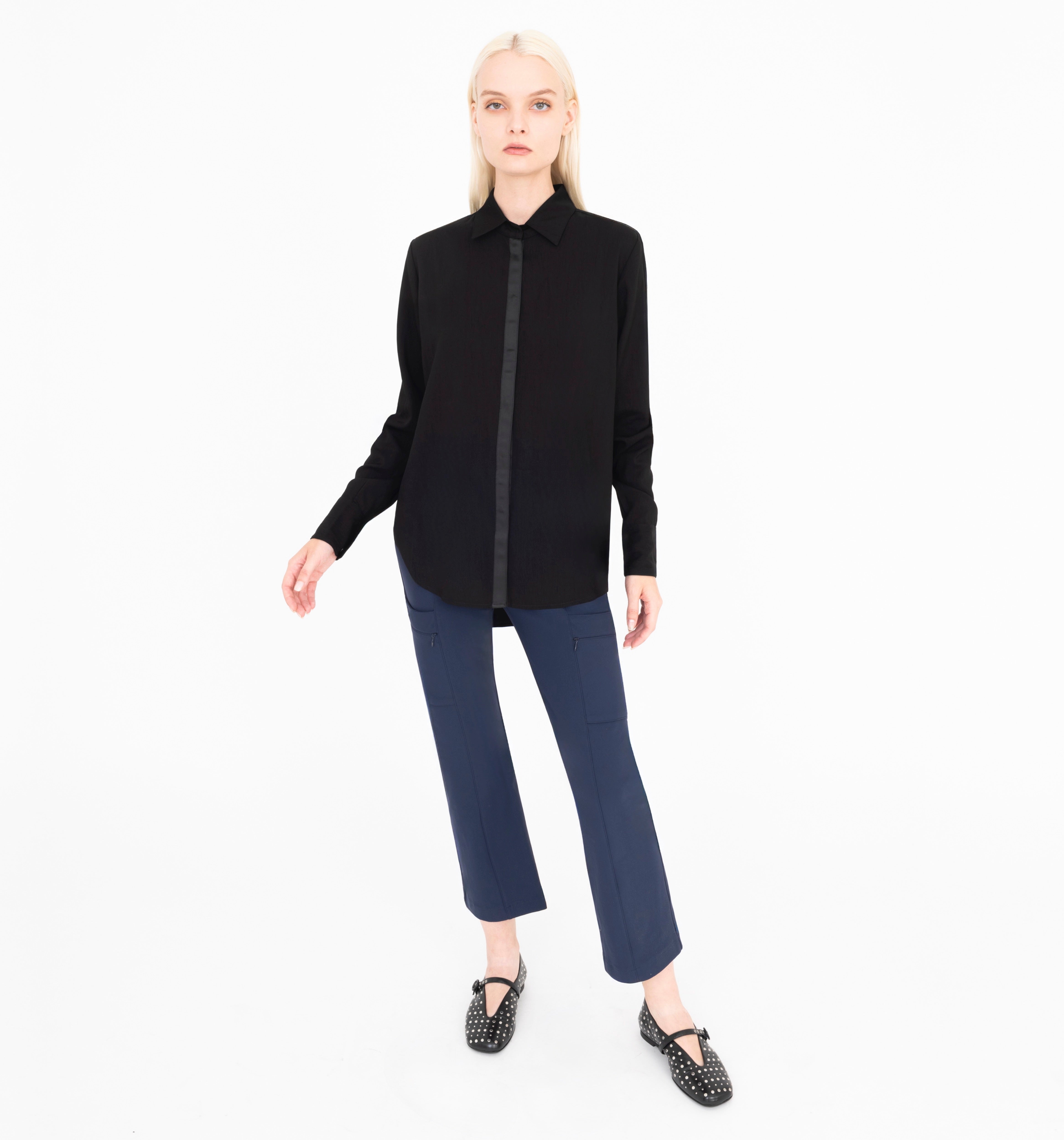 Woman wearing a black shirt and blue pants on a white background