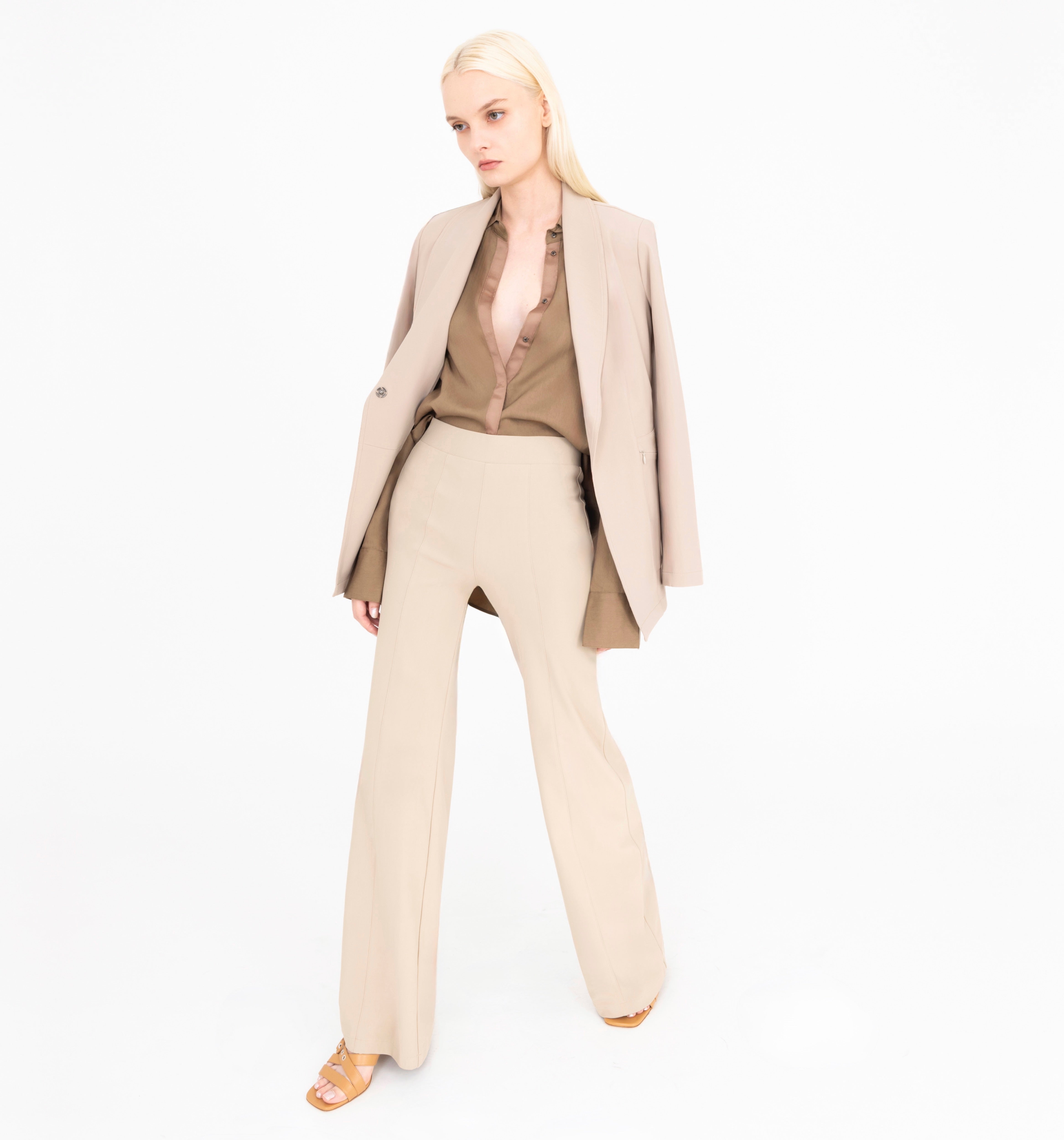 Woman wearing a beige suit on a white background