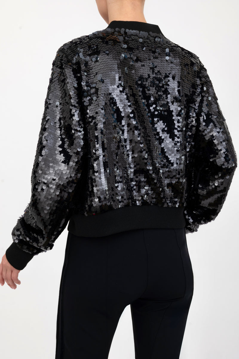 Black sequin bomber jacket worn by a model on a white background