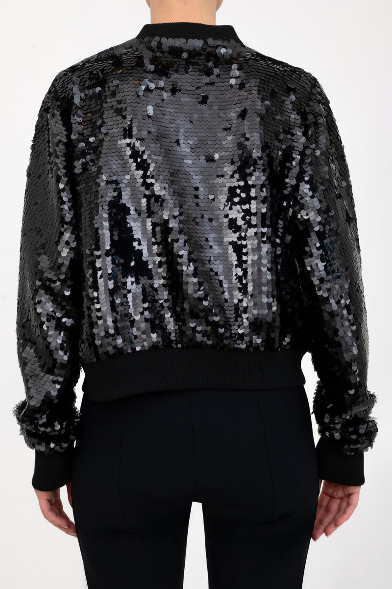 Black sequin bomber jacket worn by a model on a white background