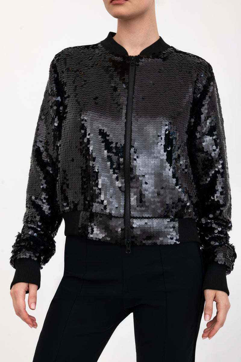 Black sequin bomber jacket worn by a model on a white background