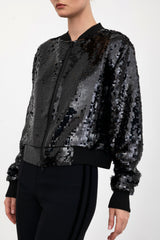Black sequin bomber jacket worn by a model on a white background