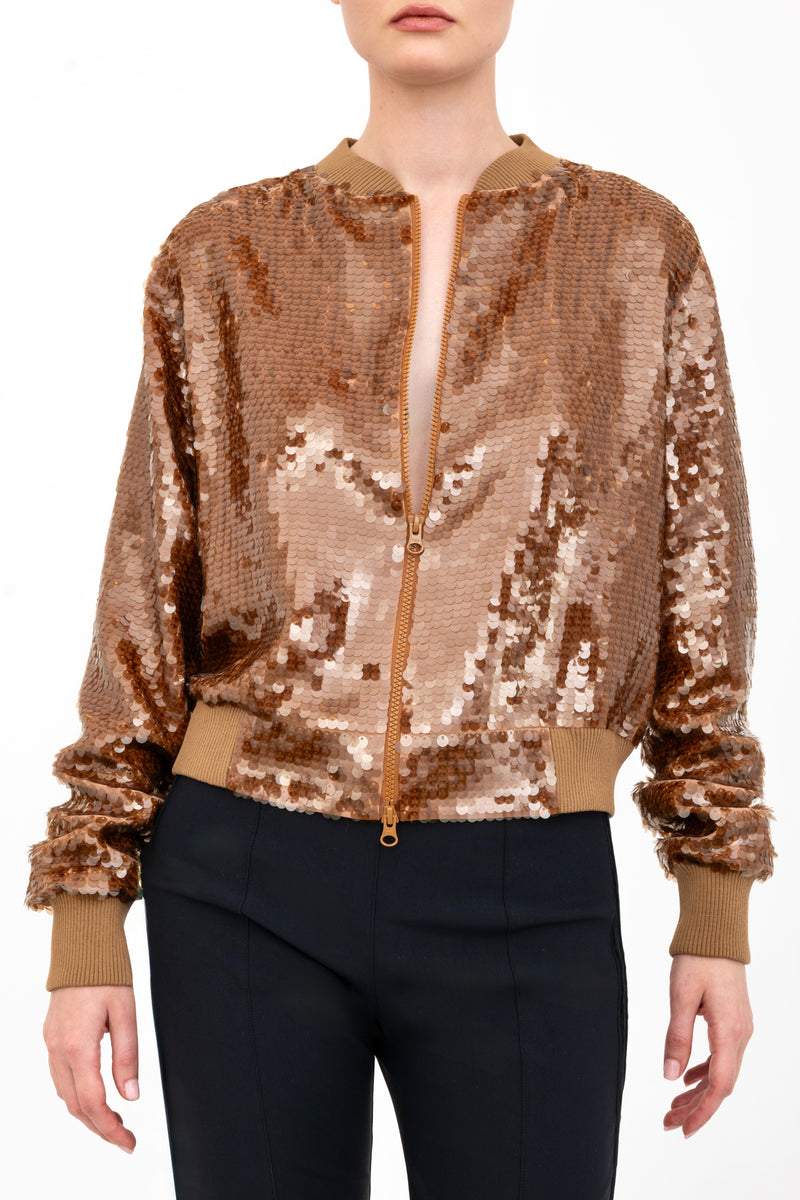 Bronze sequin bomber jacket worn by a model on a white background