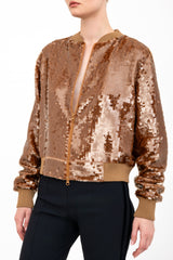 Bronze sequin bomber jacket worn by a model on a white background