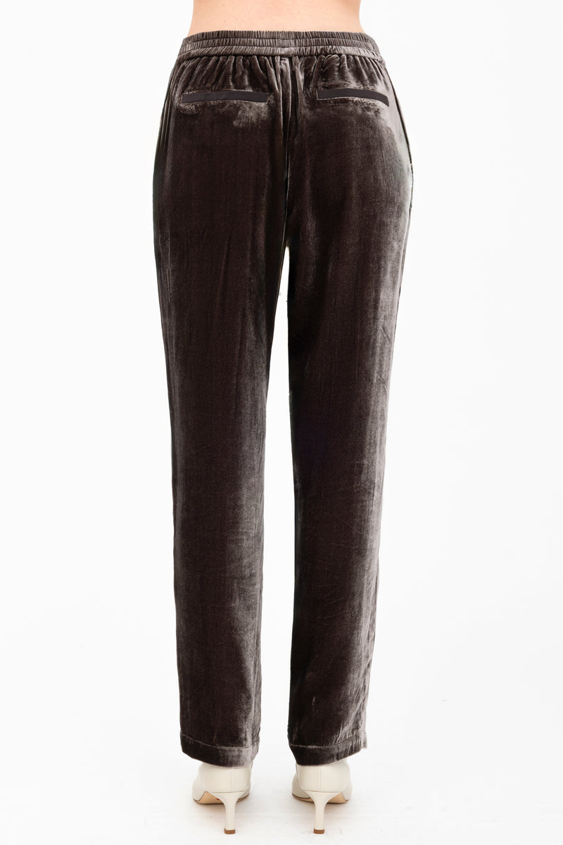 Brown velvet pants worn by a model on a white background