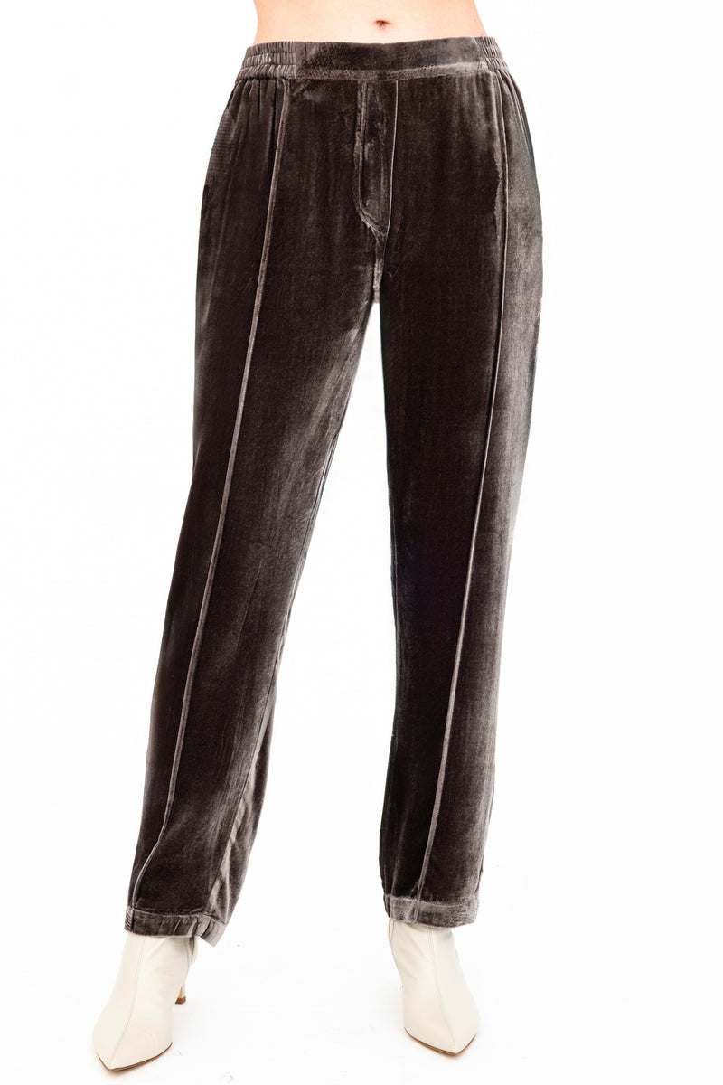 Brown velvet pants worn by a model on a white background
