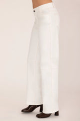 White pants worn by a person on a plain background