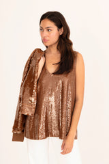 Woman wearing a bronze sequin top on a white background
