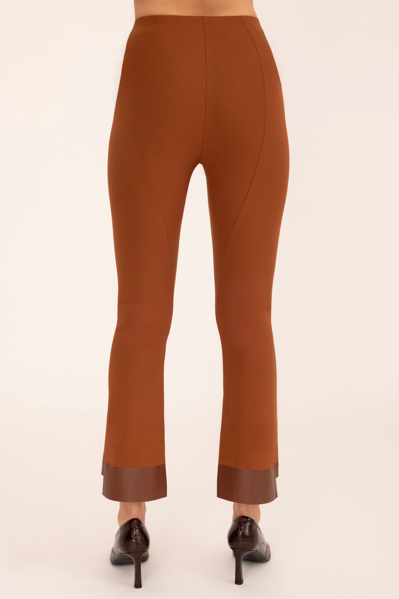 Brown pants with cuffed ankles on a beige background
