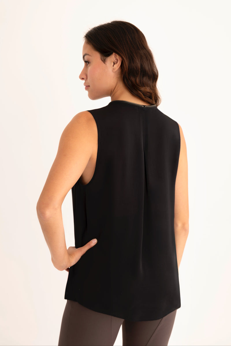 Woman wearing a black sleeveless top on a white background