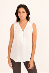 Woman wearing a white sleeveless top with a zipper on a white background