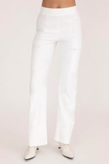 White pants worn by a person on a light pink background