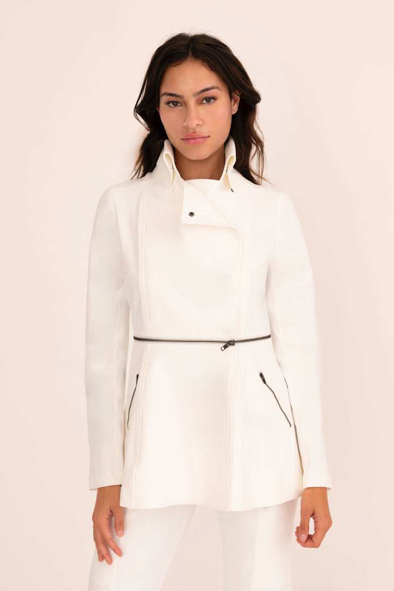 Woman wearing a white jacket on a light pink background