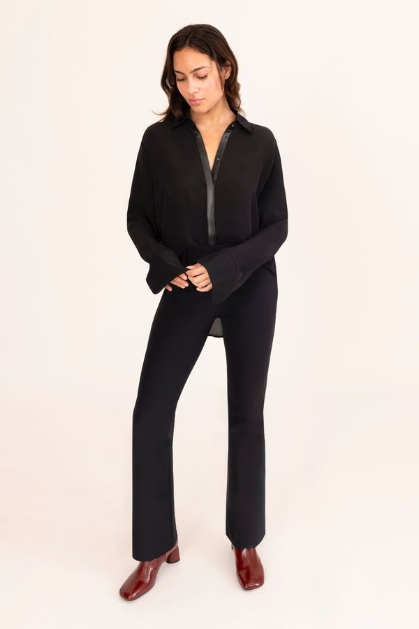 Woman wearing a black outfit on a beige background