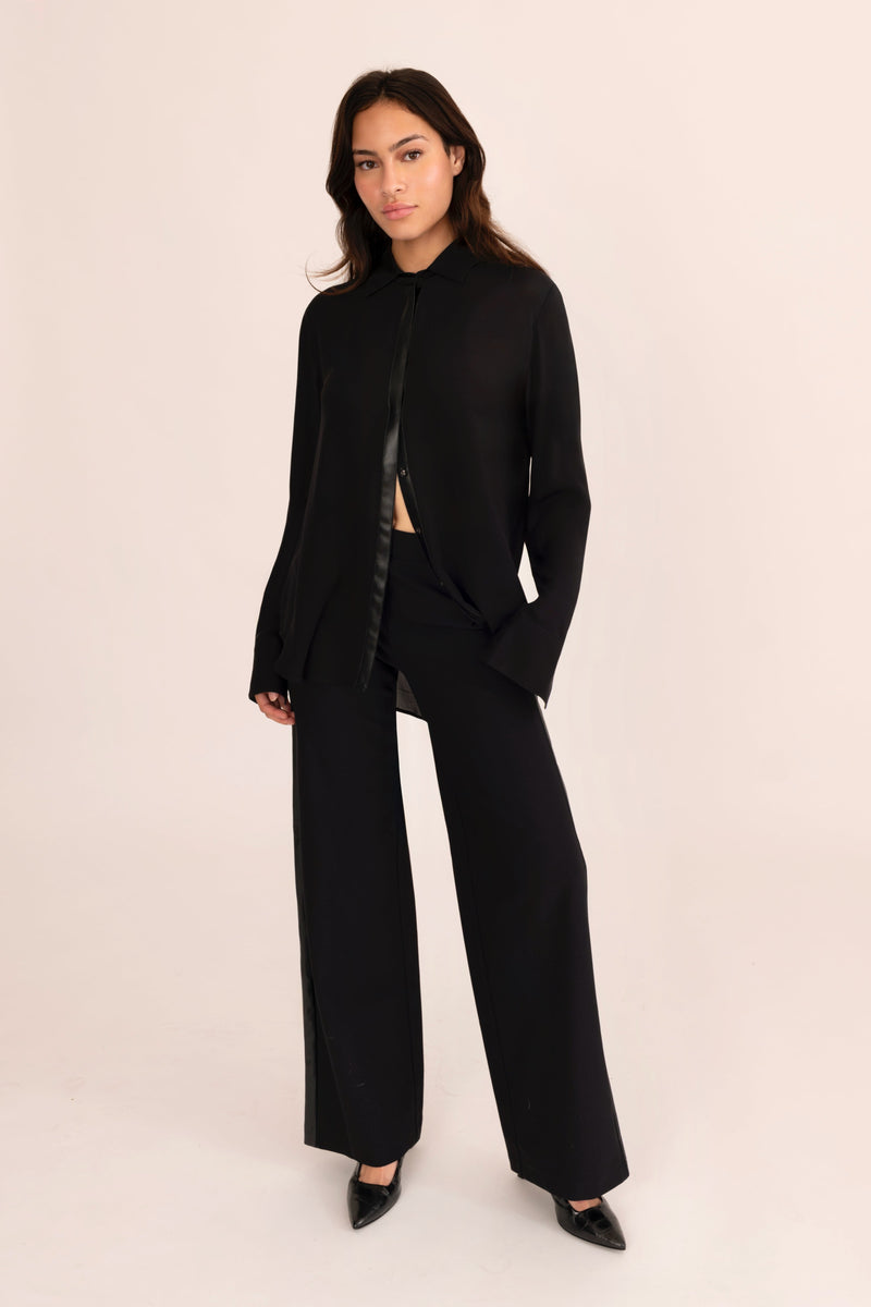 Woman wearing a black outfit on a beige background