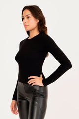 Woman wearing a black long-sleeve top and black leather pants on a white background
