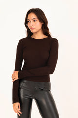 Woman wearing a brown long-sleeve top and black leather pants on a white background
