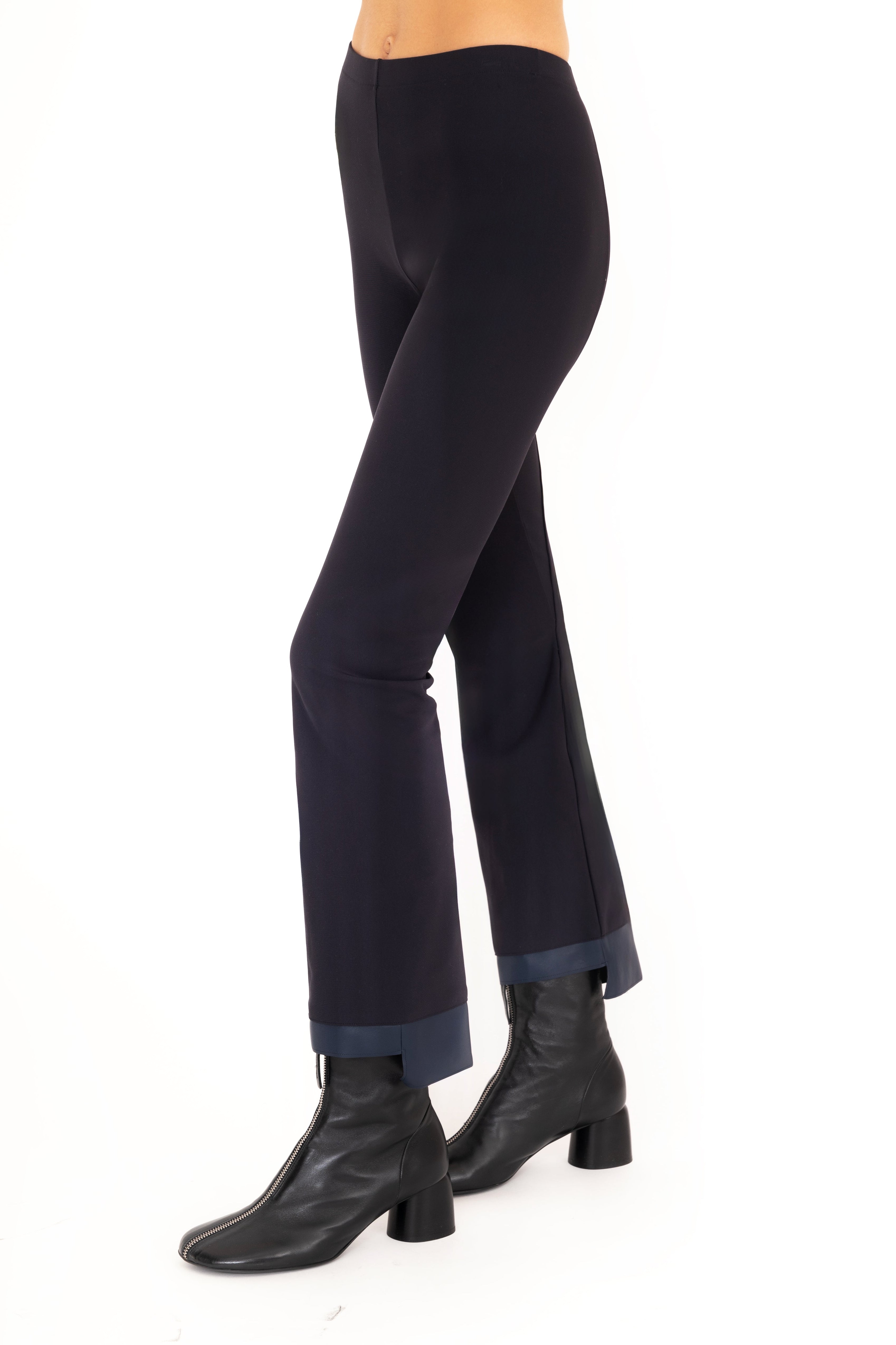 Dark blue pants worn by a person on a white background