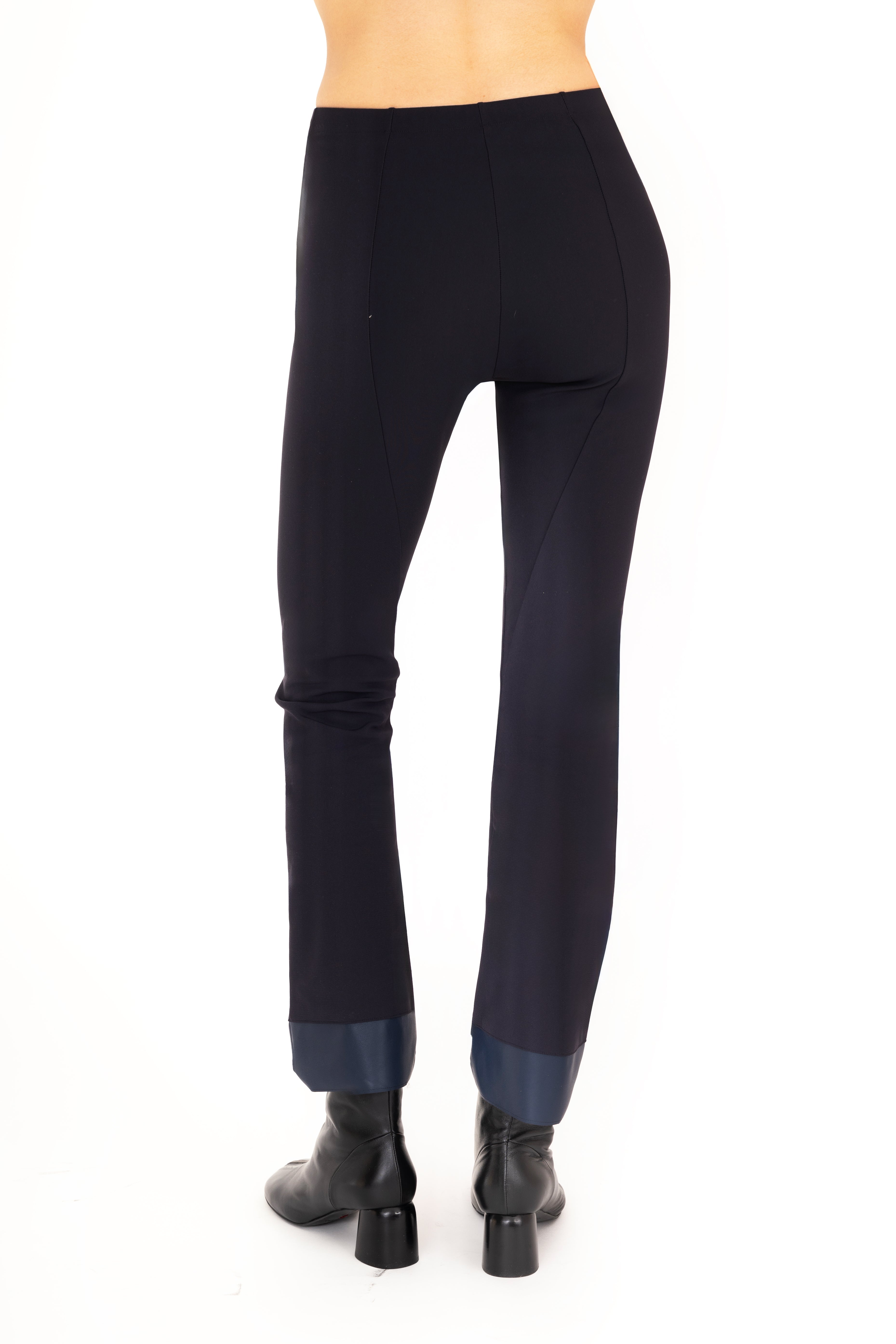 Dark blue pants worn by a person on a white background