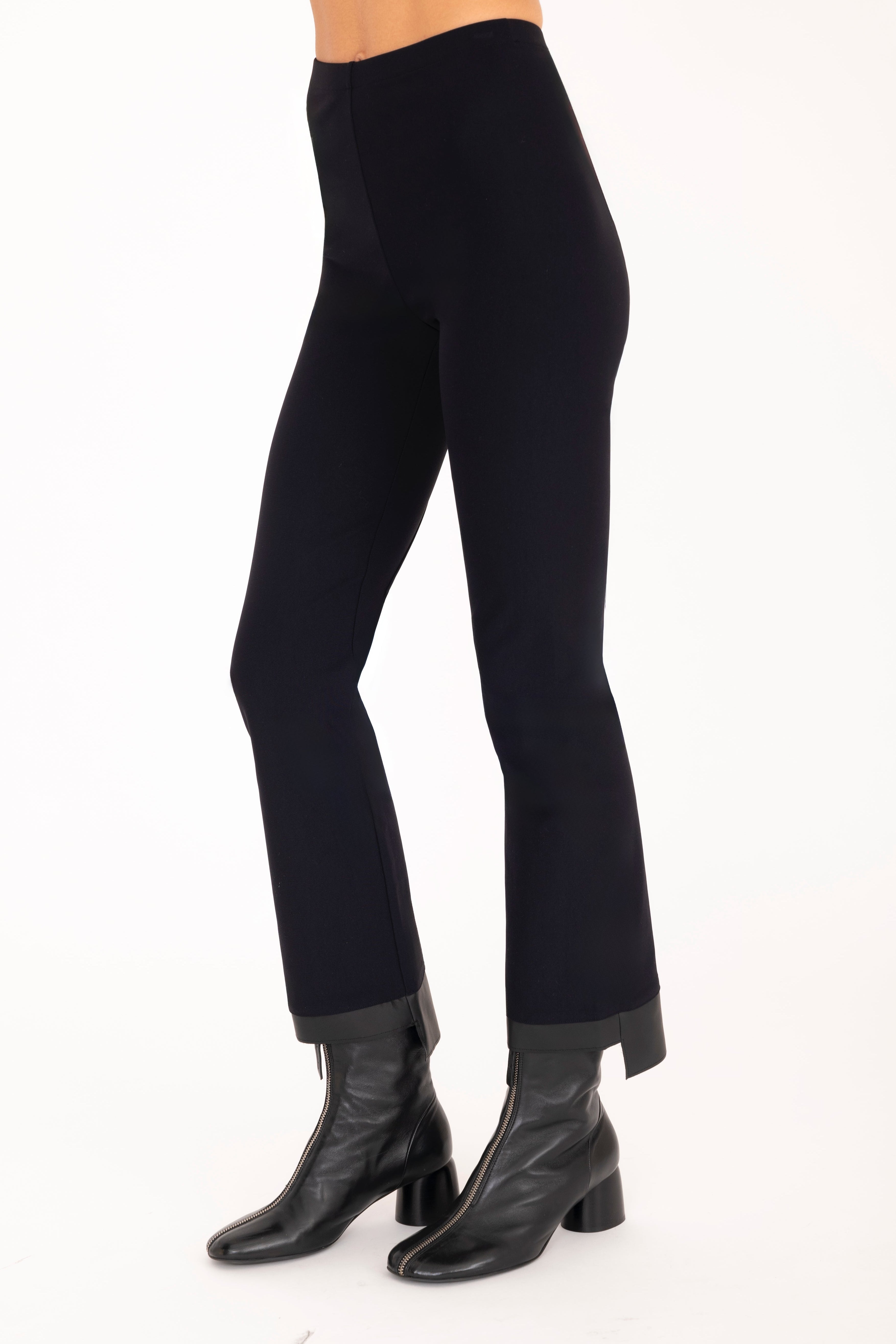 Black pants worn by a person on a white background
