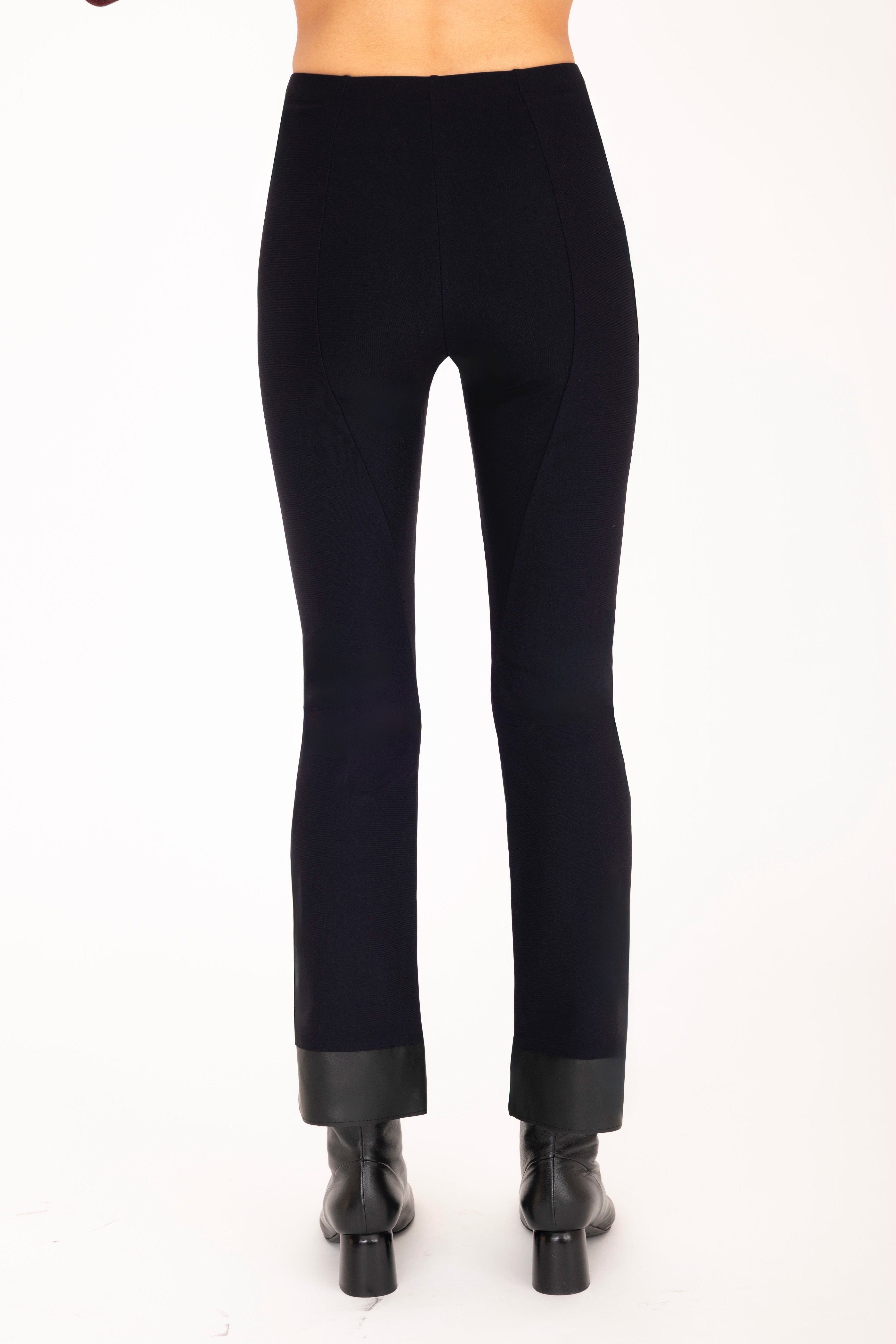 Black pants worn by a person on a white background