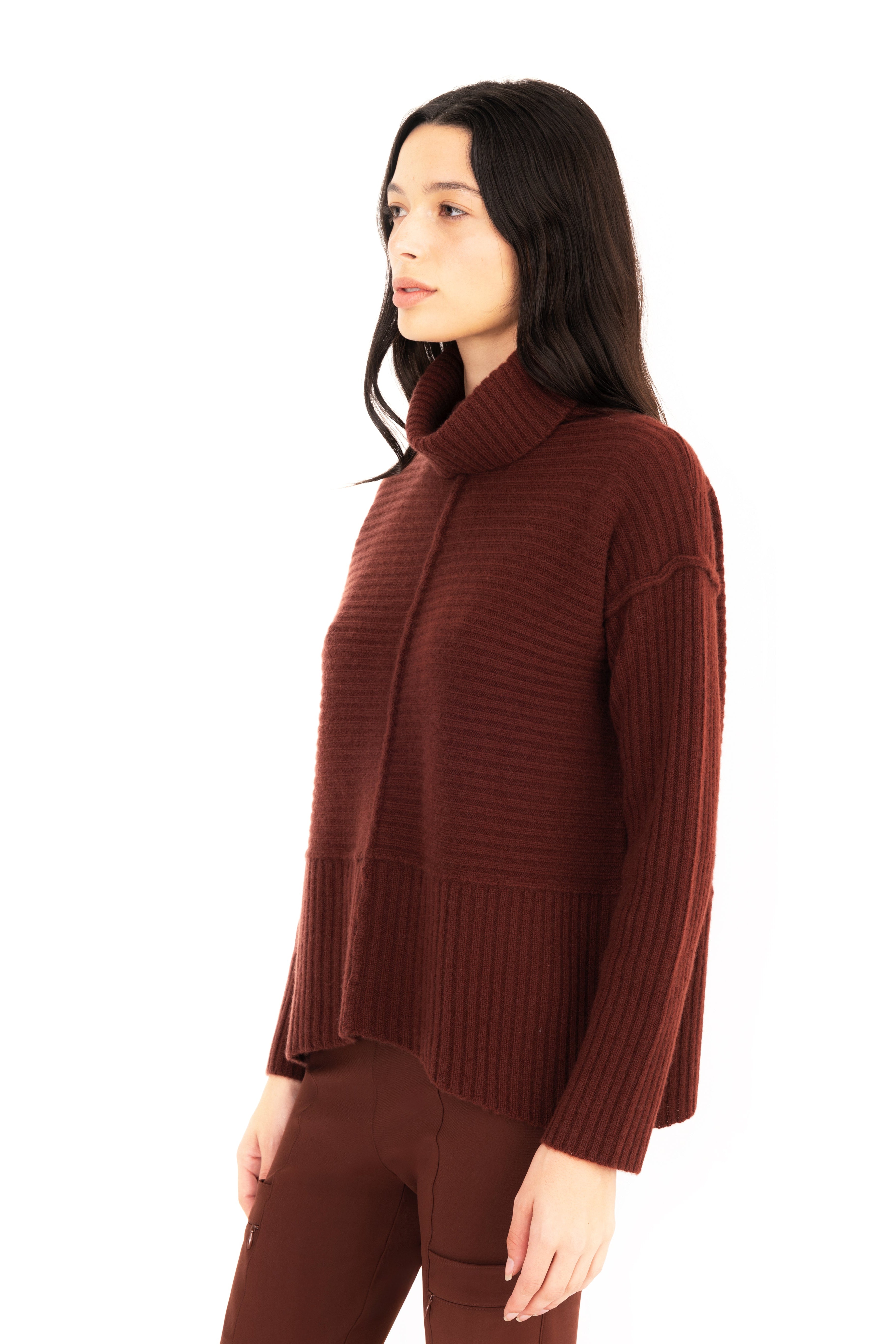 Woman wearing a brown ribbed sweater on a white background