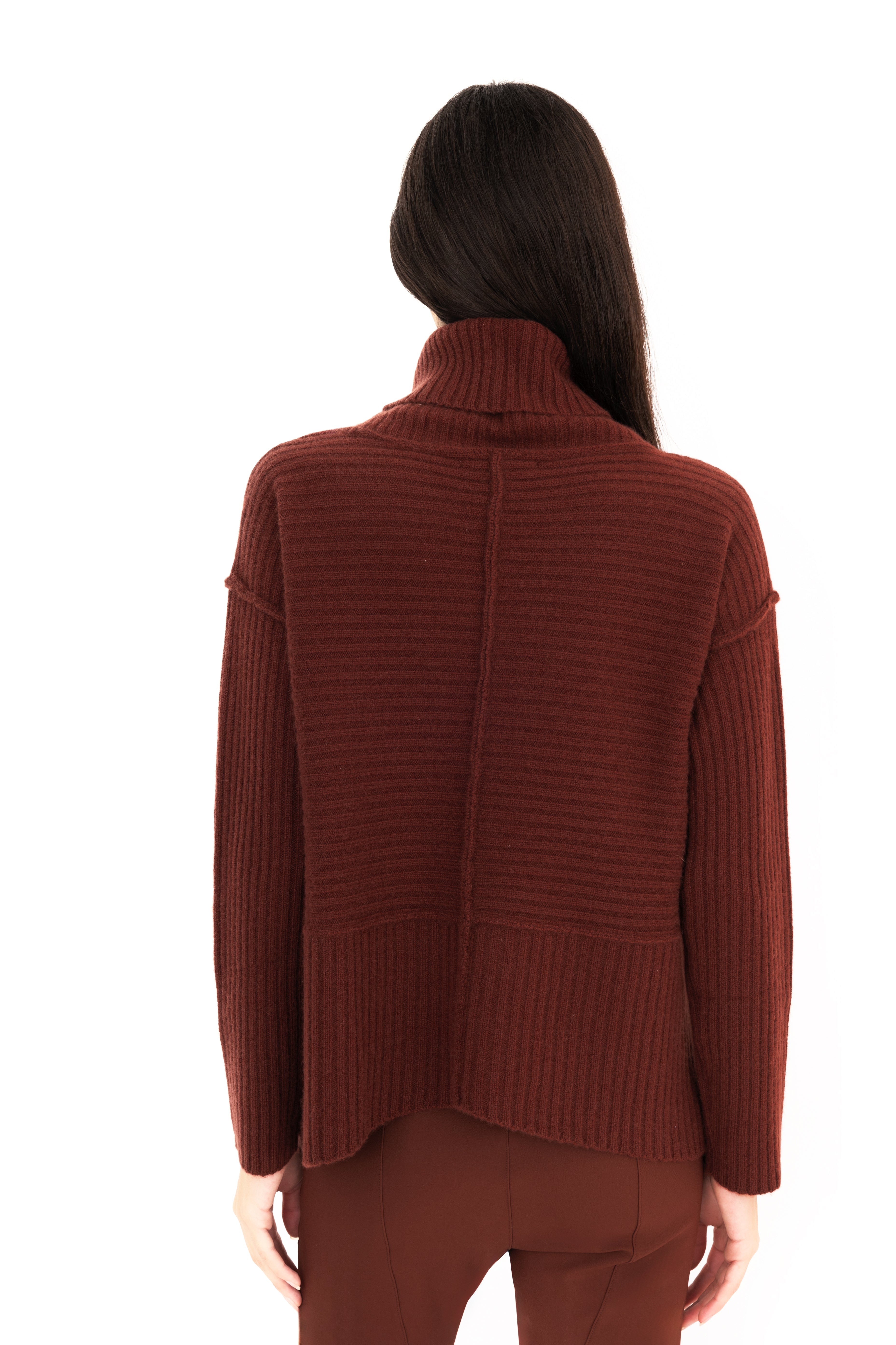 Woman wearing a brown ribbed sweater on a white background