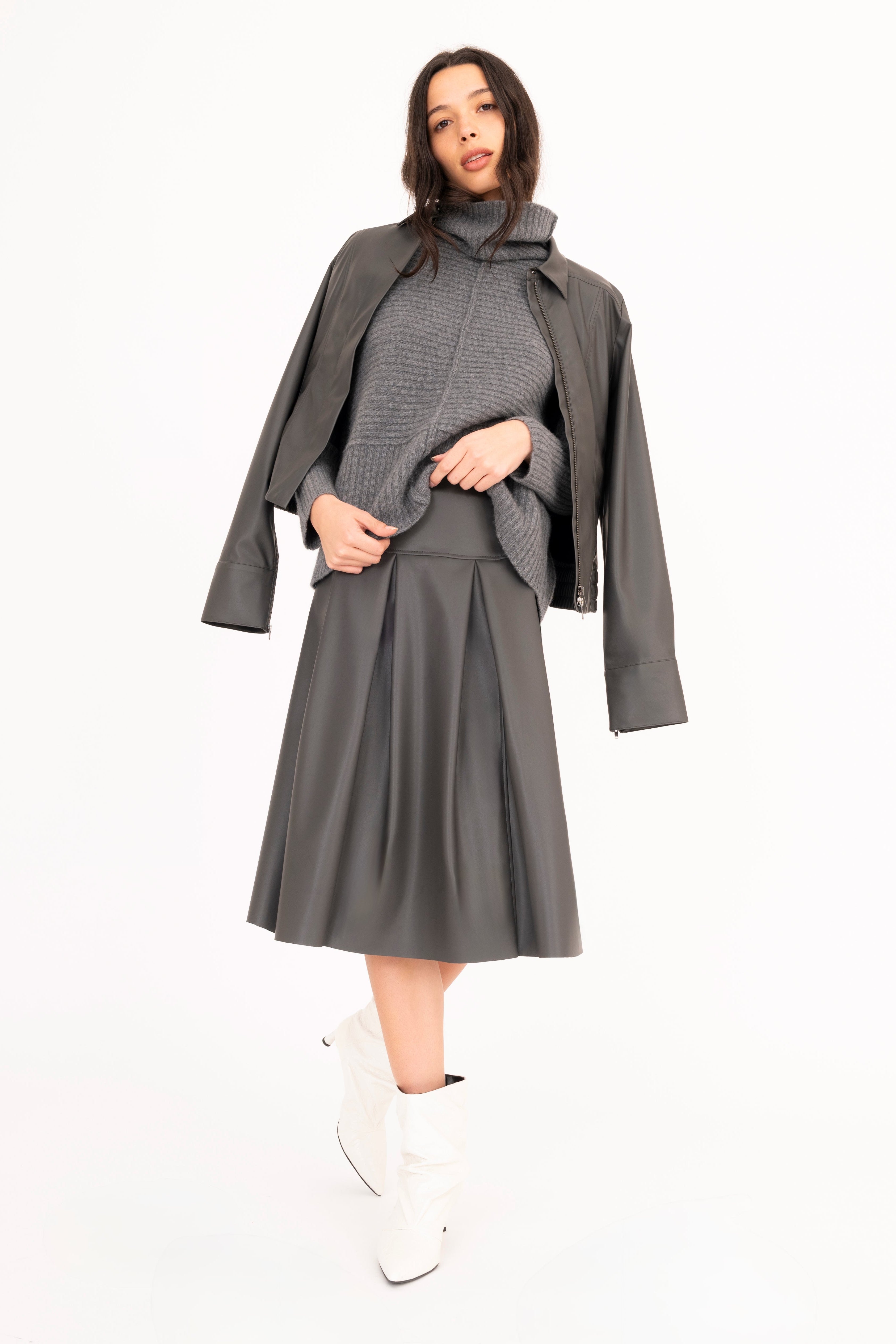 Woman wearing a gray dress with a matching coat on a white background