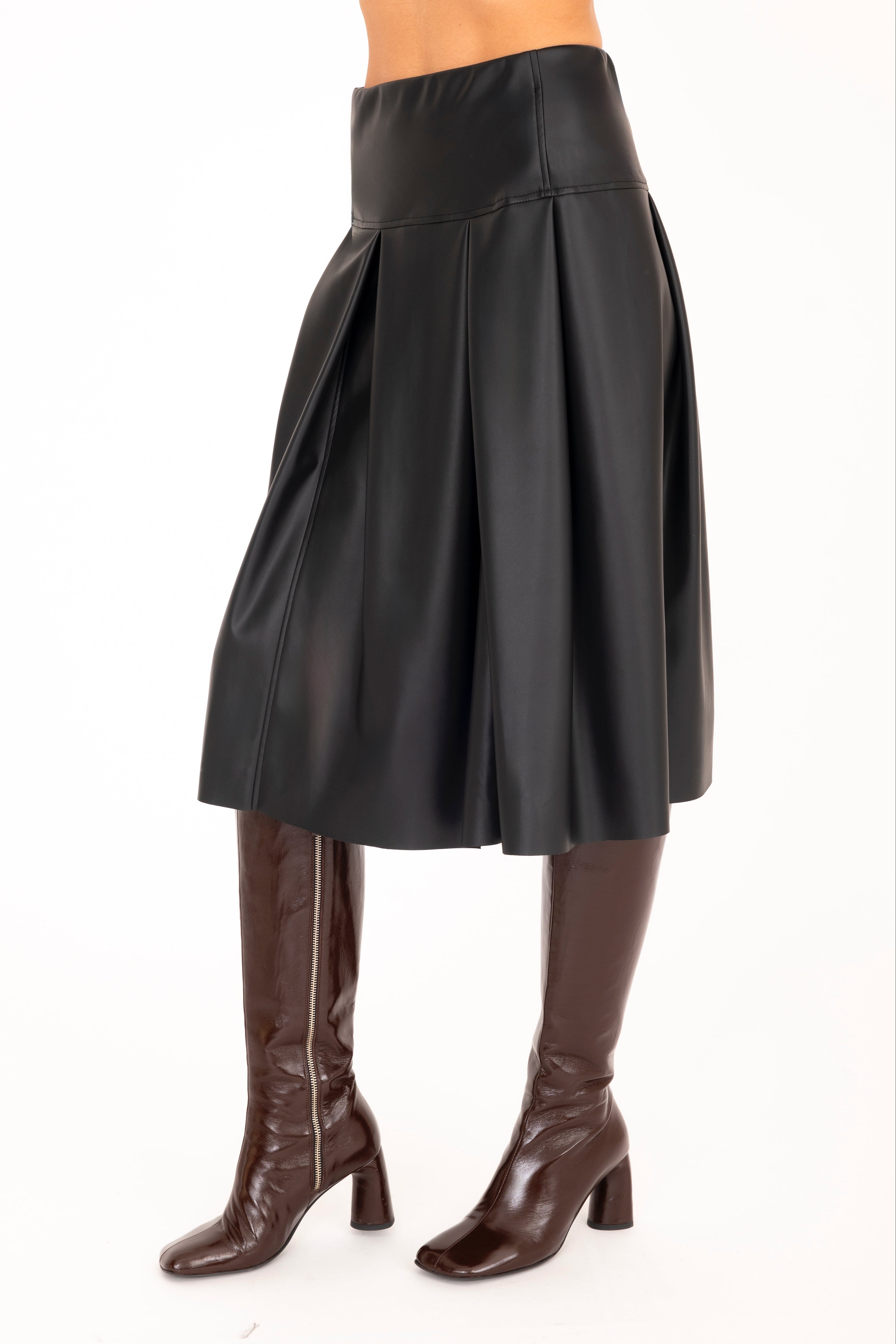 Black leather skirt worn by a person on a white background
