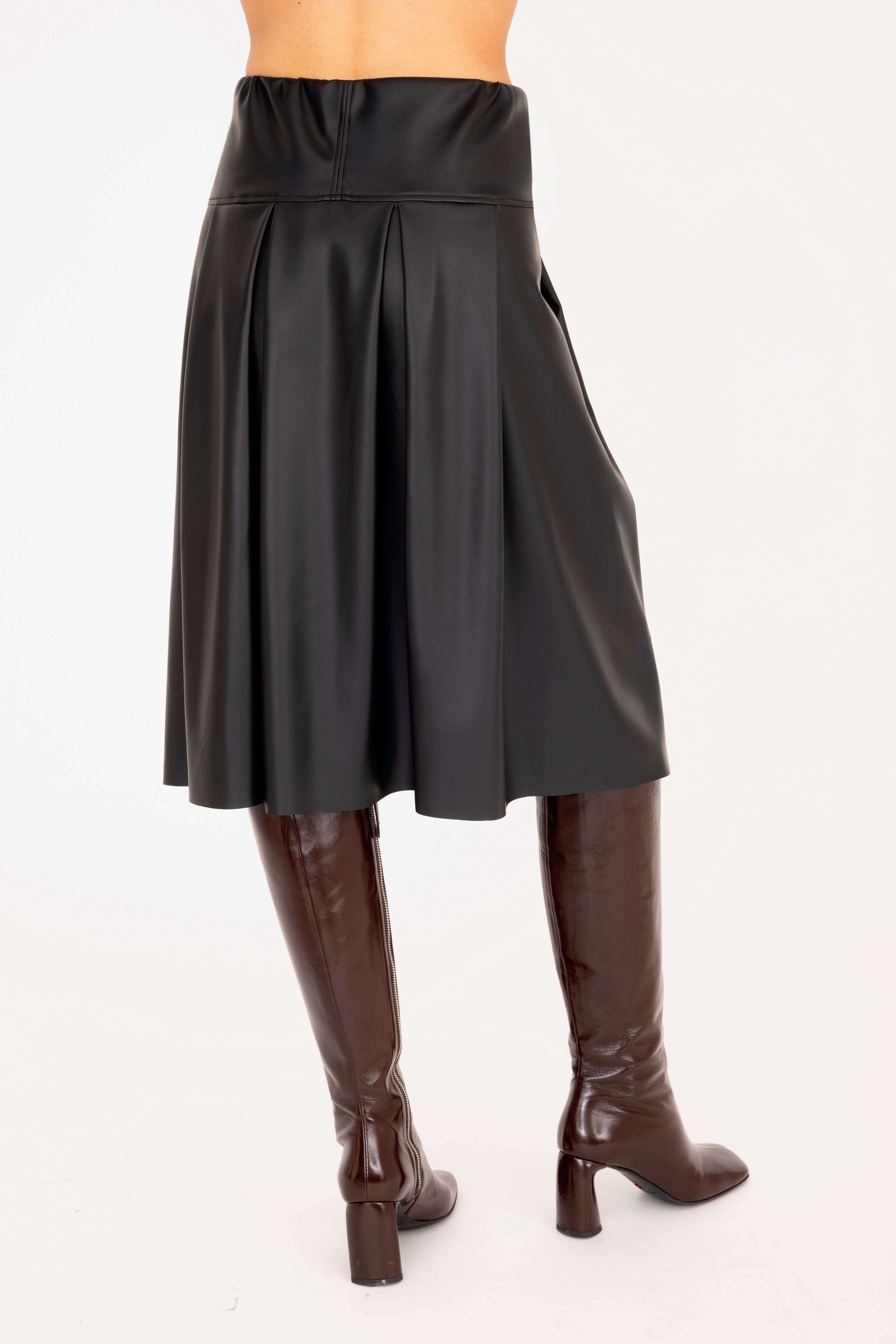 Black leather skirt worn by a person on a white background