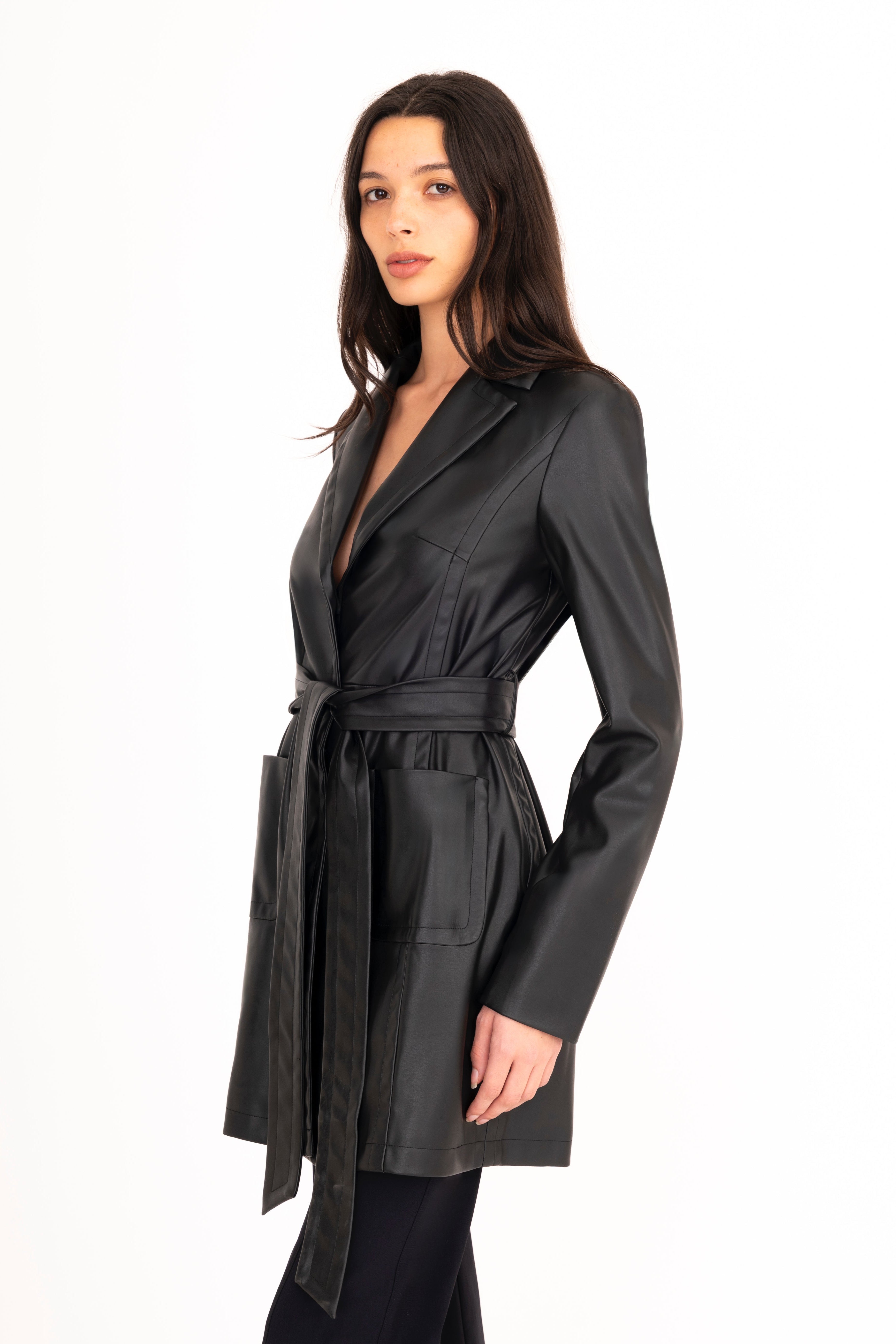 Woman wearing a black trench coat on a white background