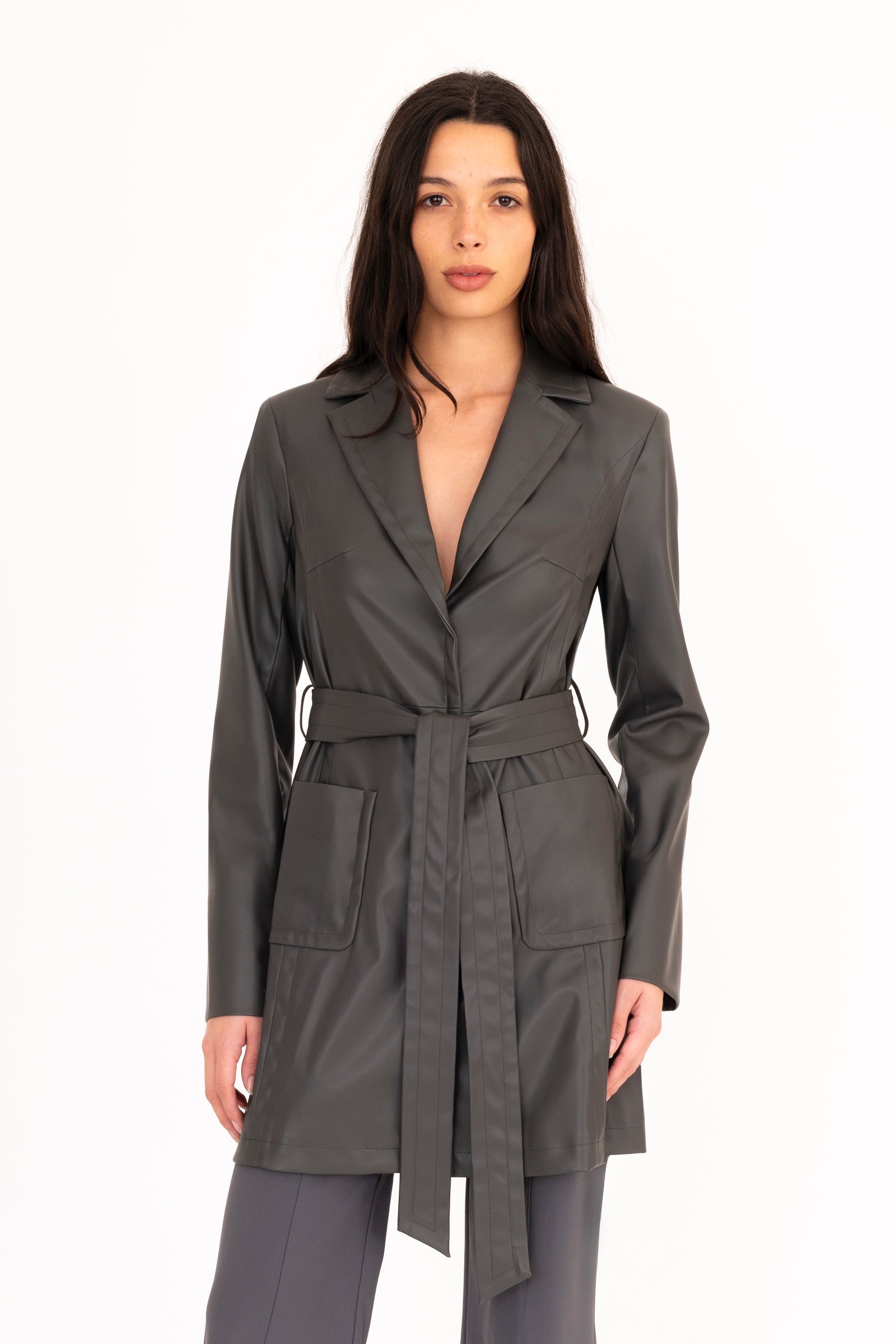 Woman wearing a gray trench coat and pants on a white background