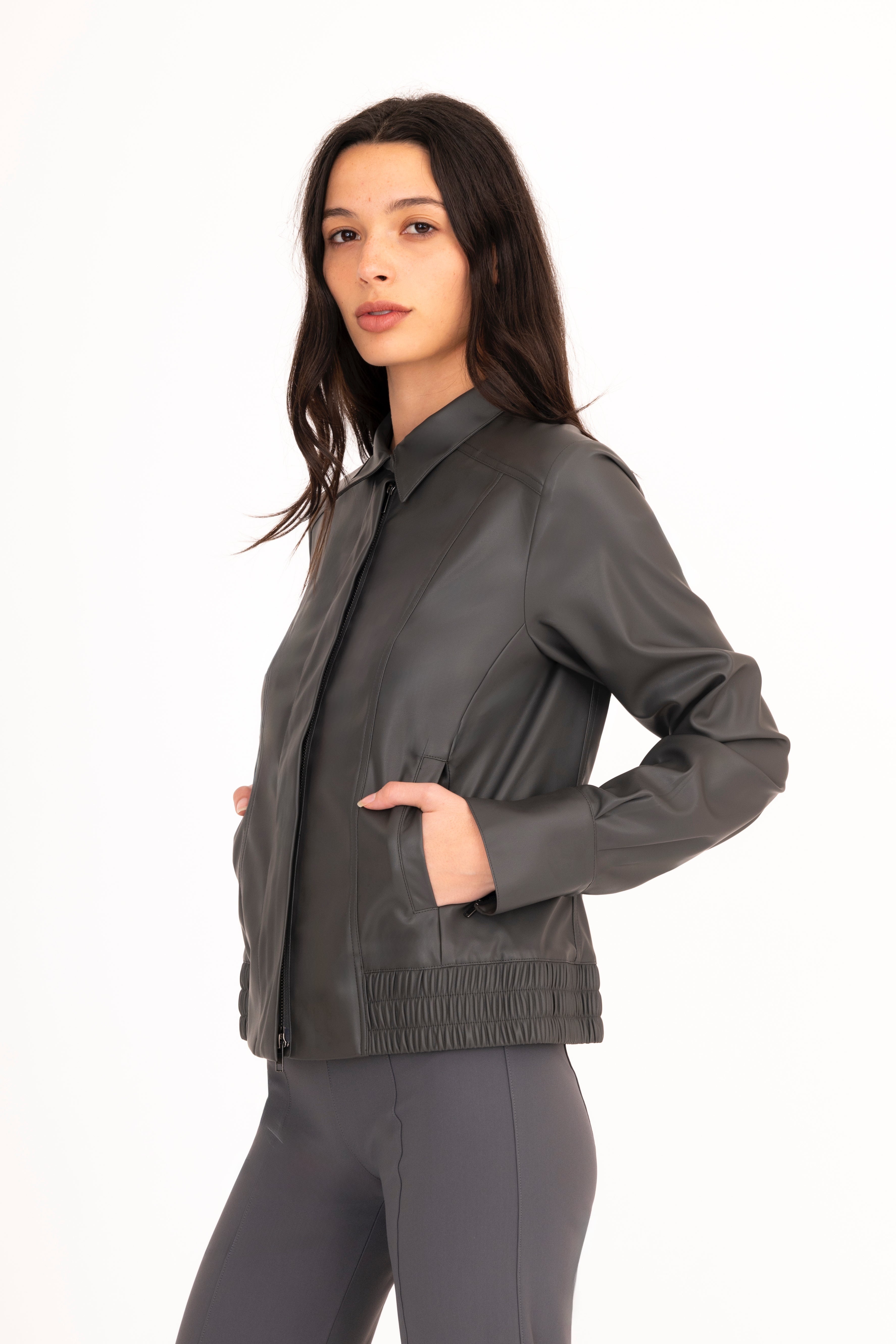 Woman wearing a gray jacket and pants on a white background