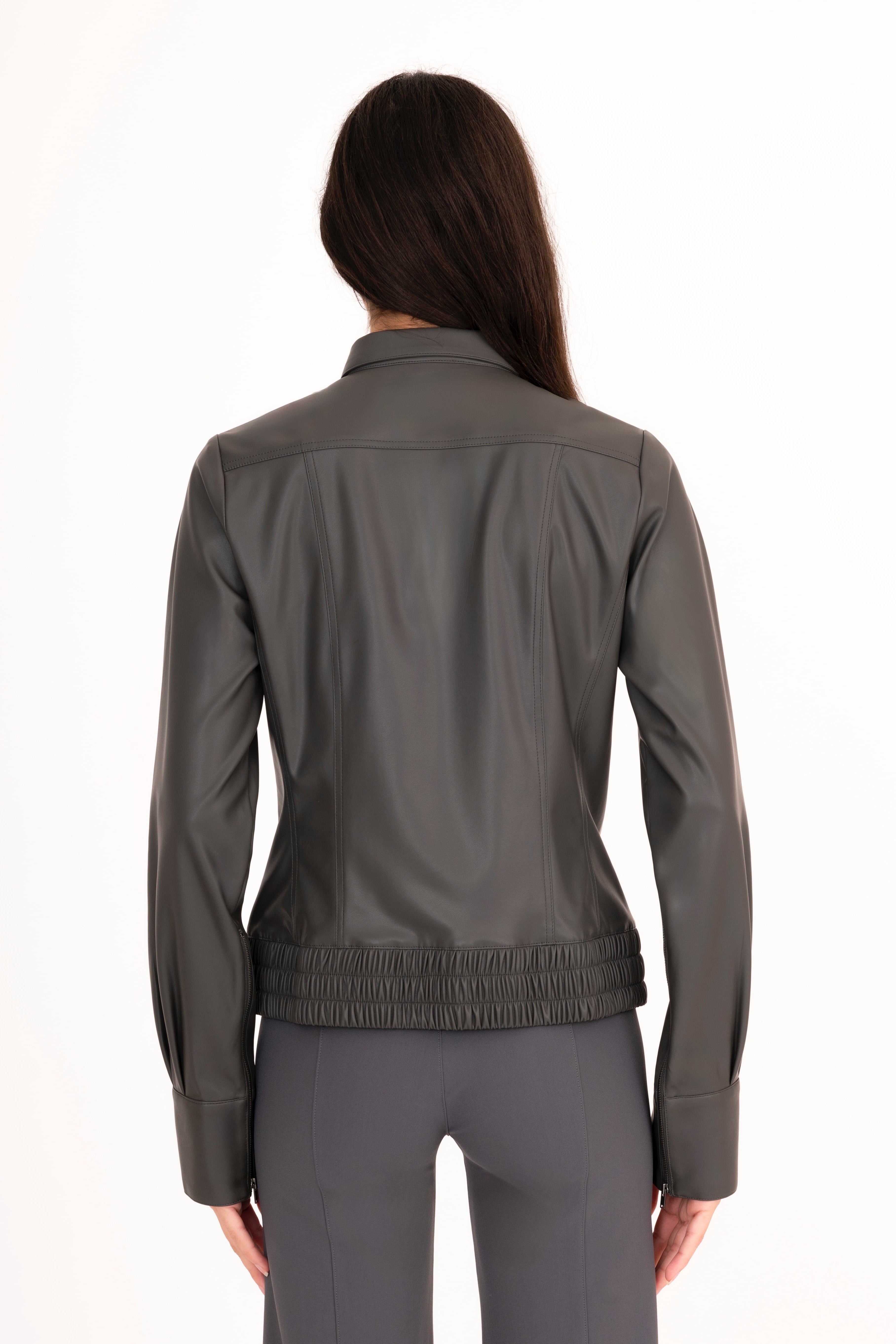 Person wearing a gray jacket and pants on a white background