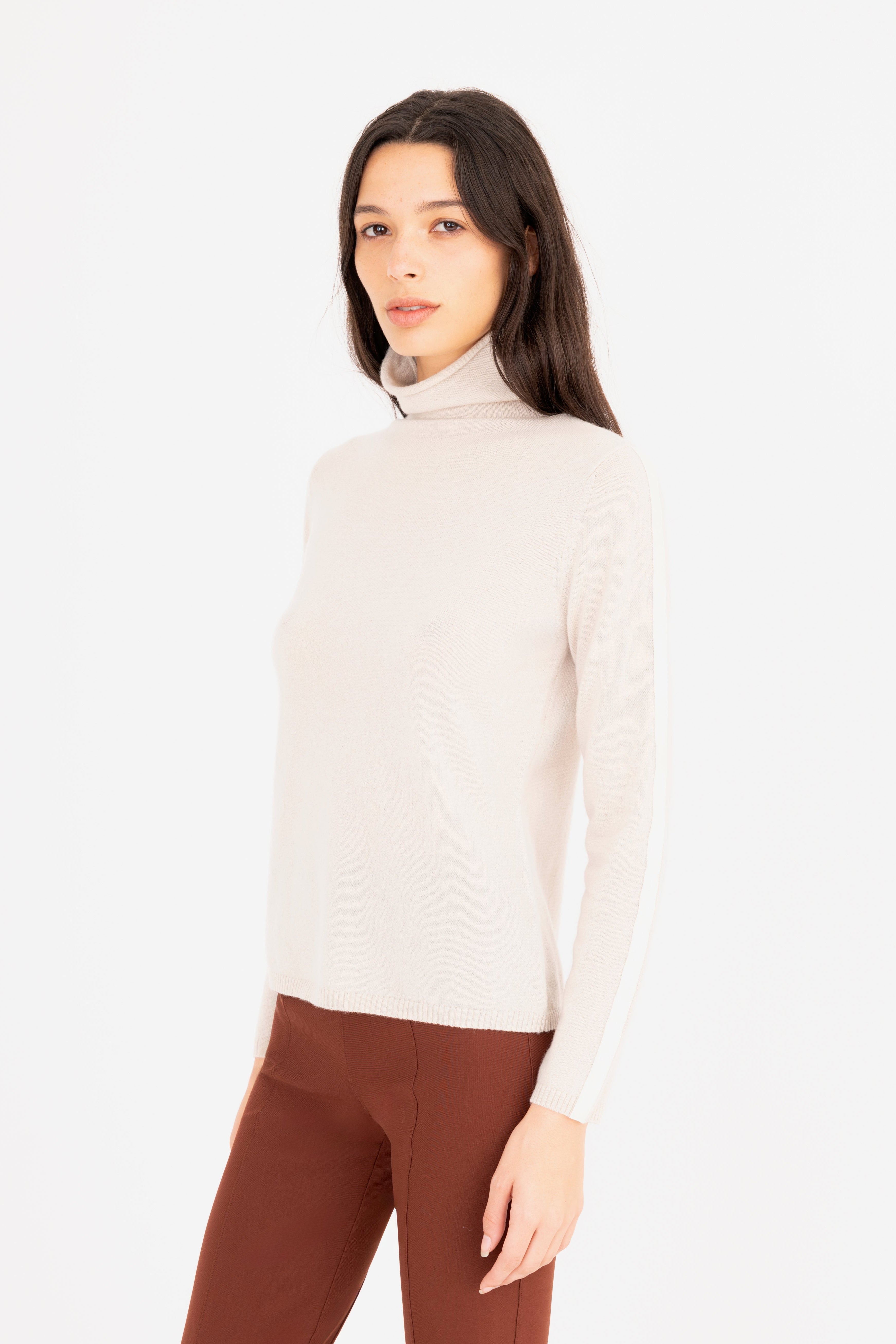 Woman wearing a beige turtleneck sweater on a white background