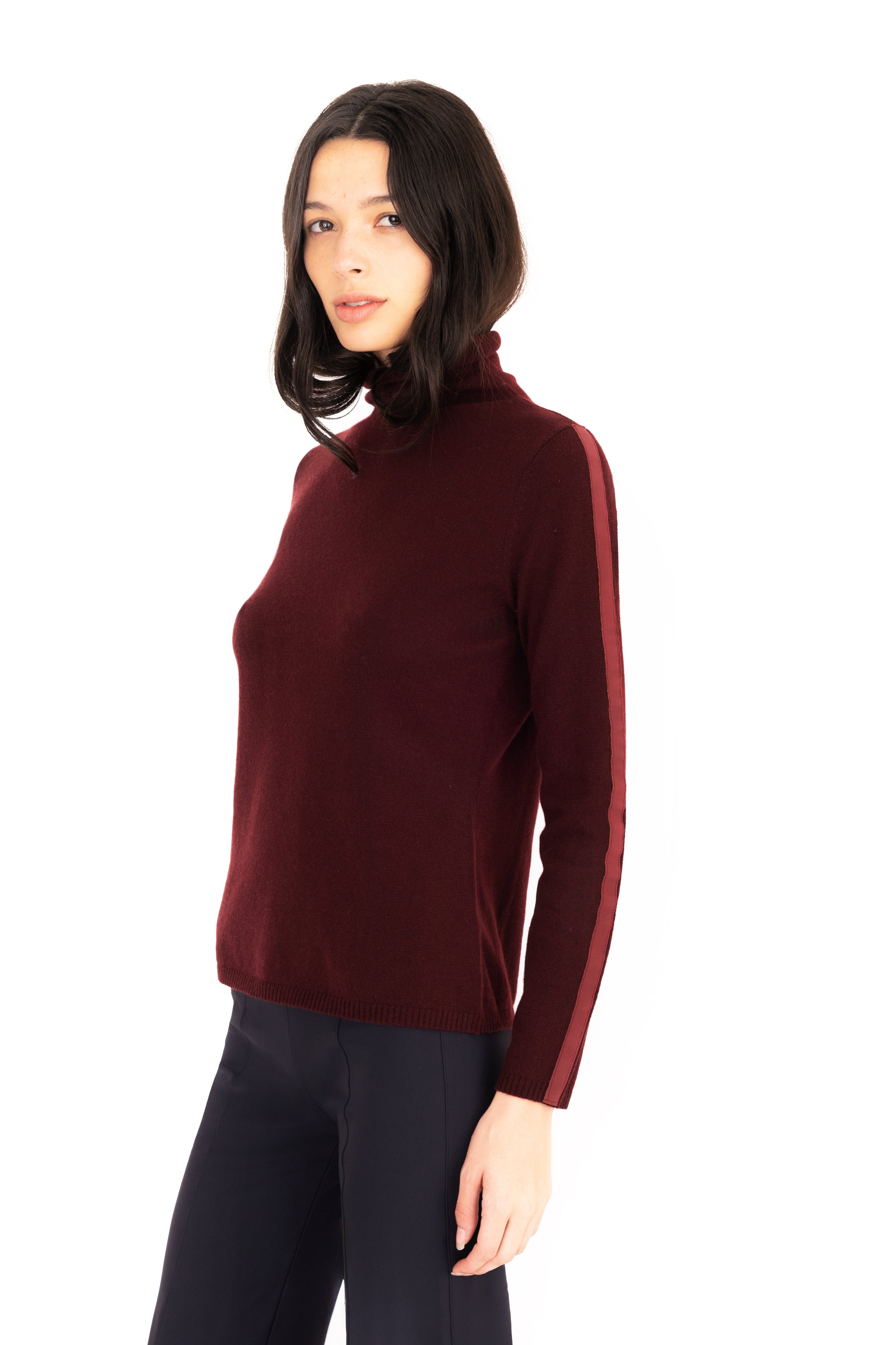 Woman wearing a burgundy turtleneck sweater on a white 