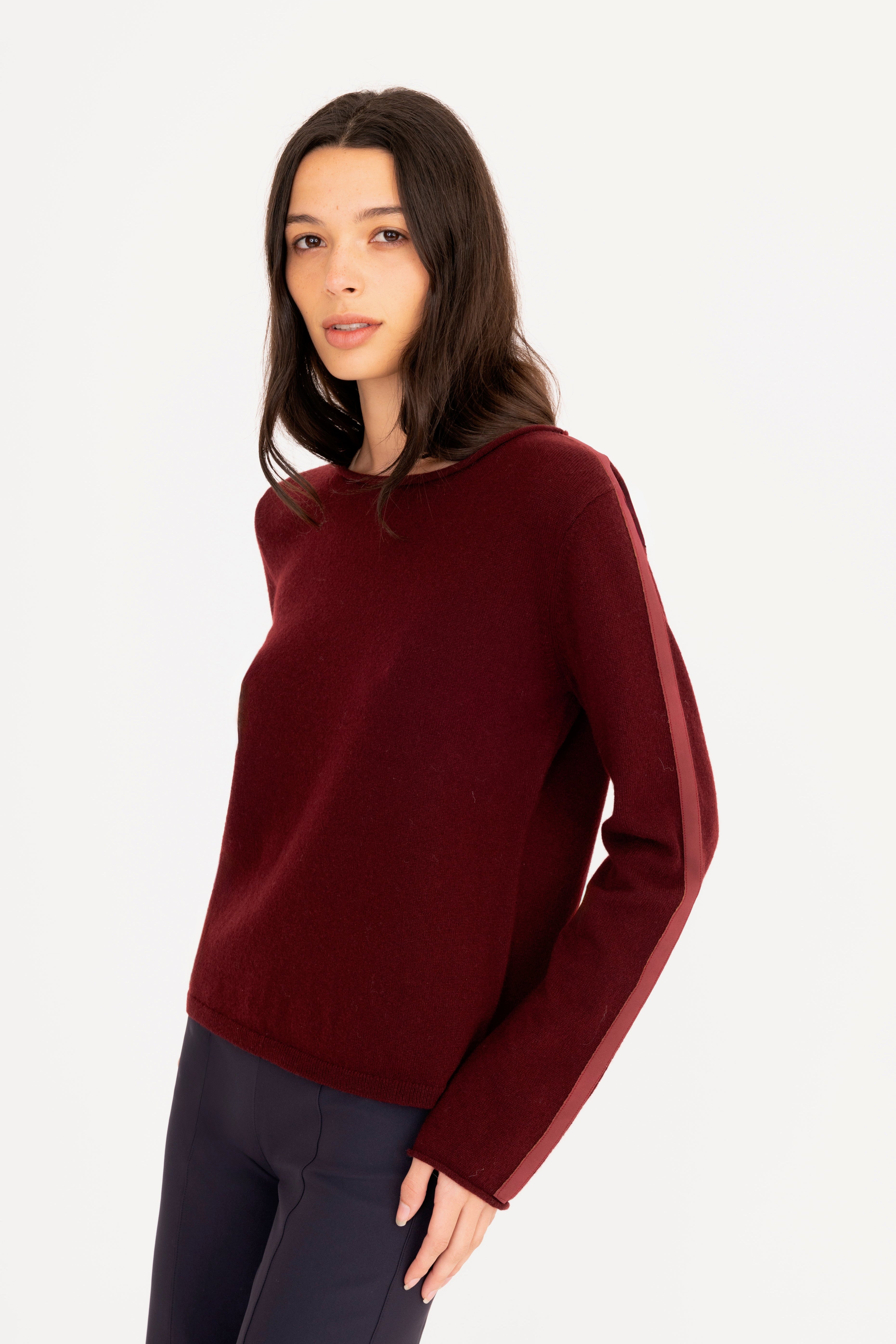 Woman wearing a burgundy sweater on a white background