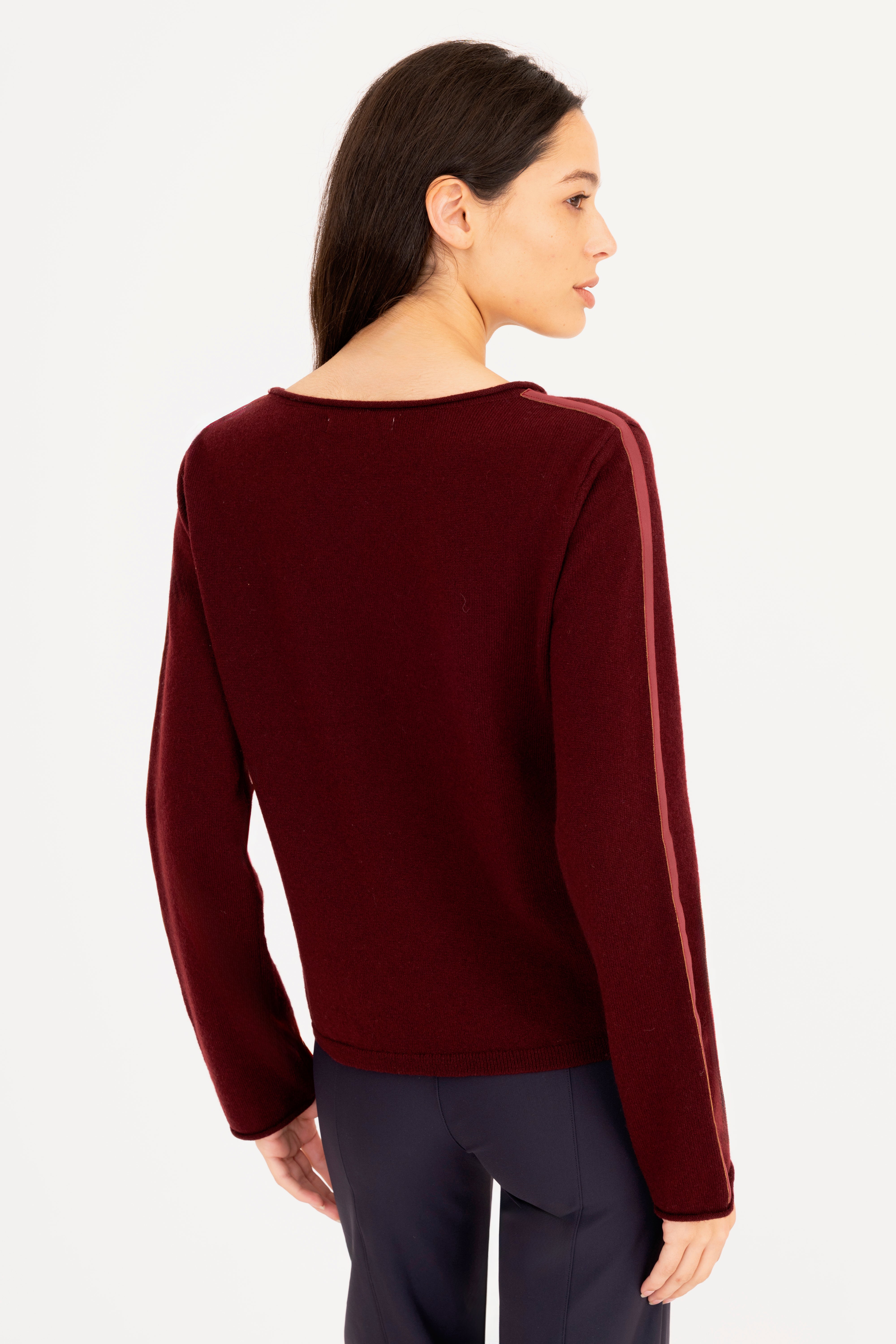 Woman wearing a burgundy sweater on a white background