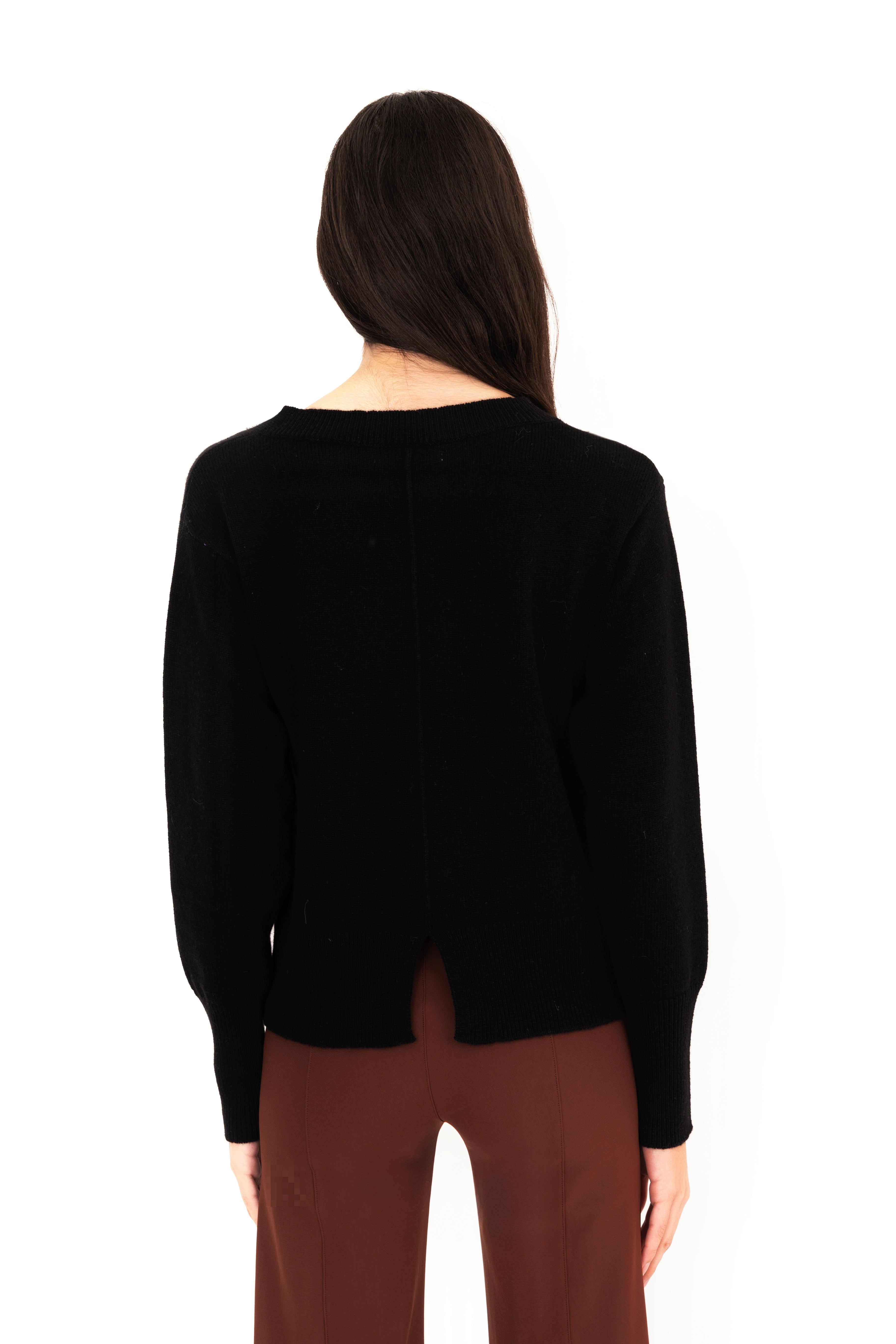 Person wearing a black sweater and brown pants on a white background