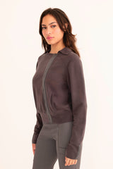 Woman wearing a dark grey moto sweater on a white background