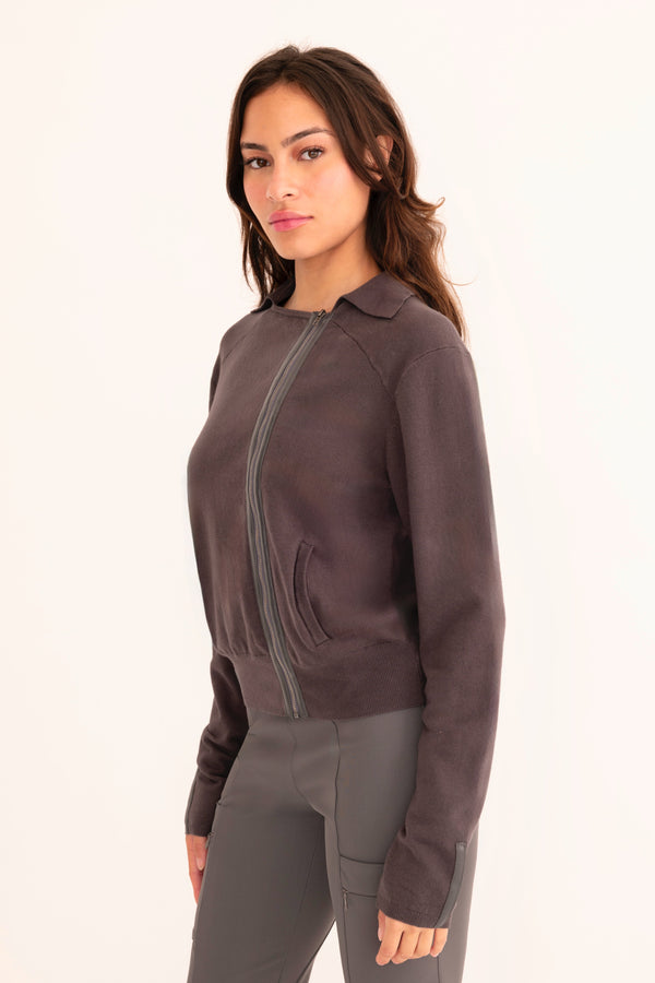 Woman wearing a dark grey moto sweater on a white background