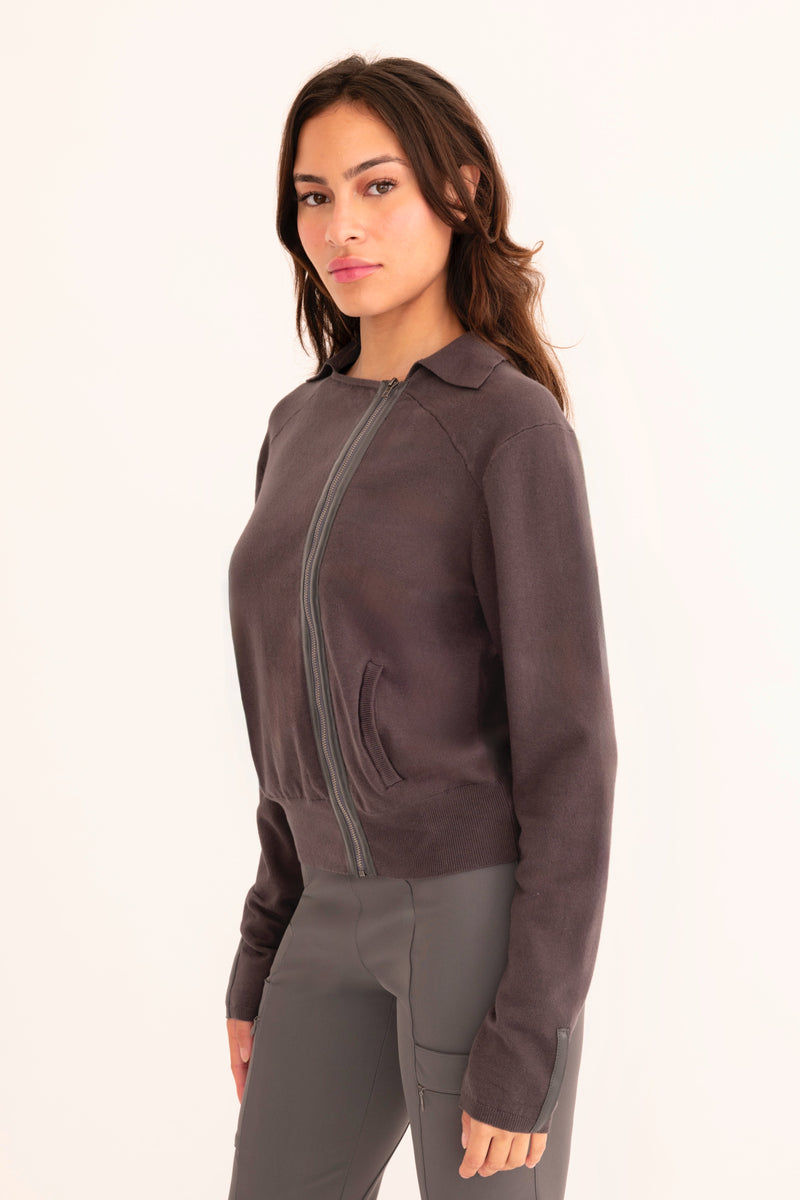 Woman wearing a dark grey moto sweater on a white background